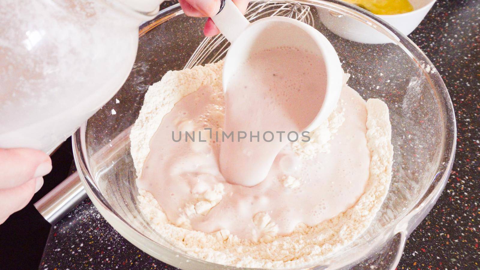 Mixing ingredients in a glass mixing bowl to make homemade pancakes.