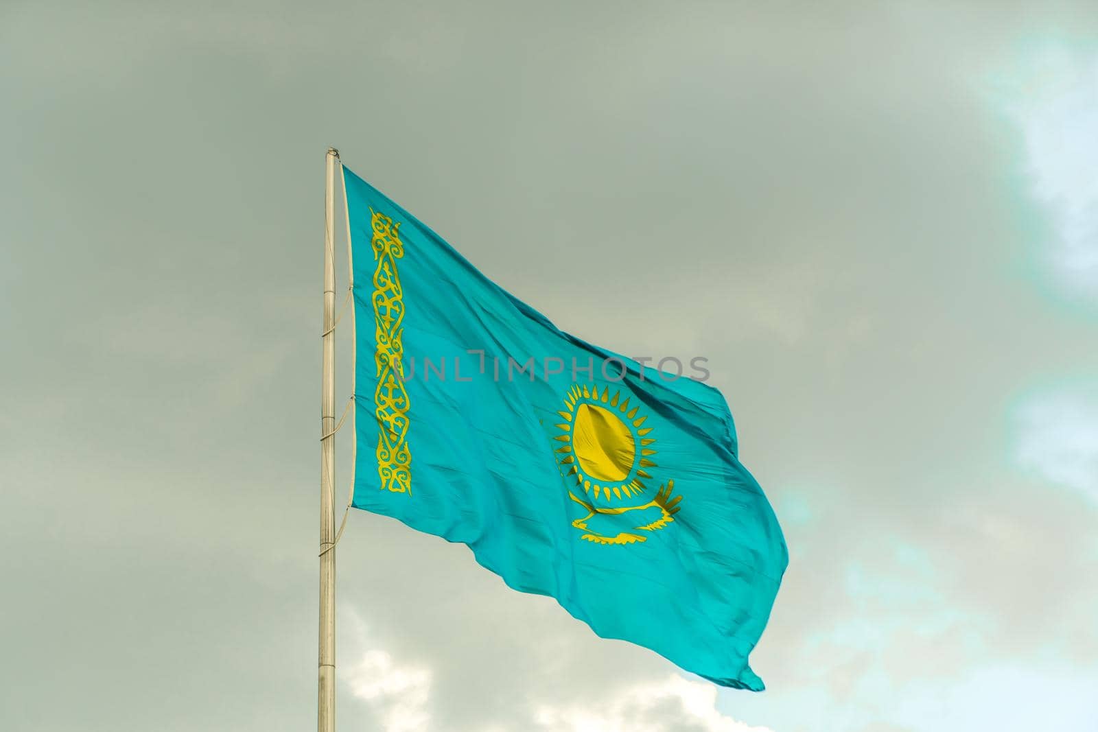 Flag of Kazakhstan on sky background. Waving flag of Republic of Kazakhstan. Fabric textures flowing flag of Kazakhstan. by YevgeniySam