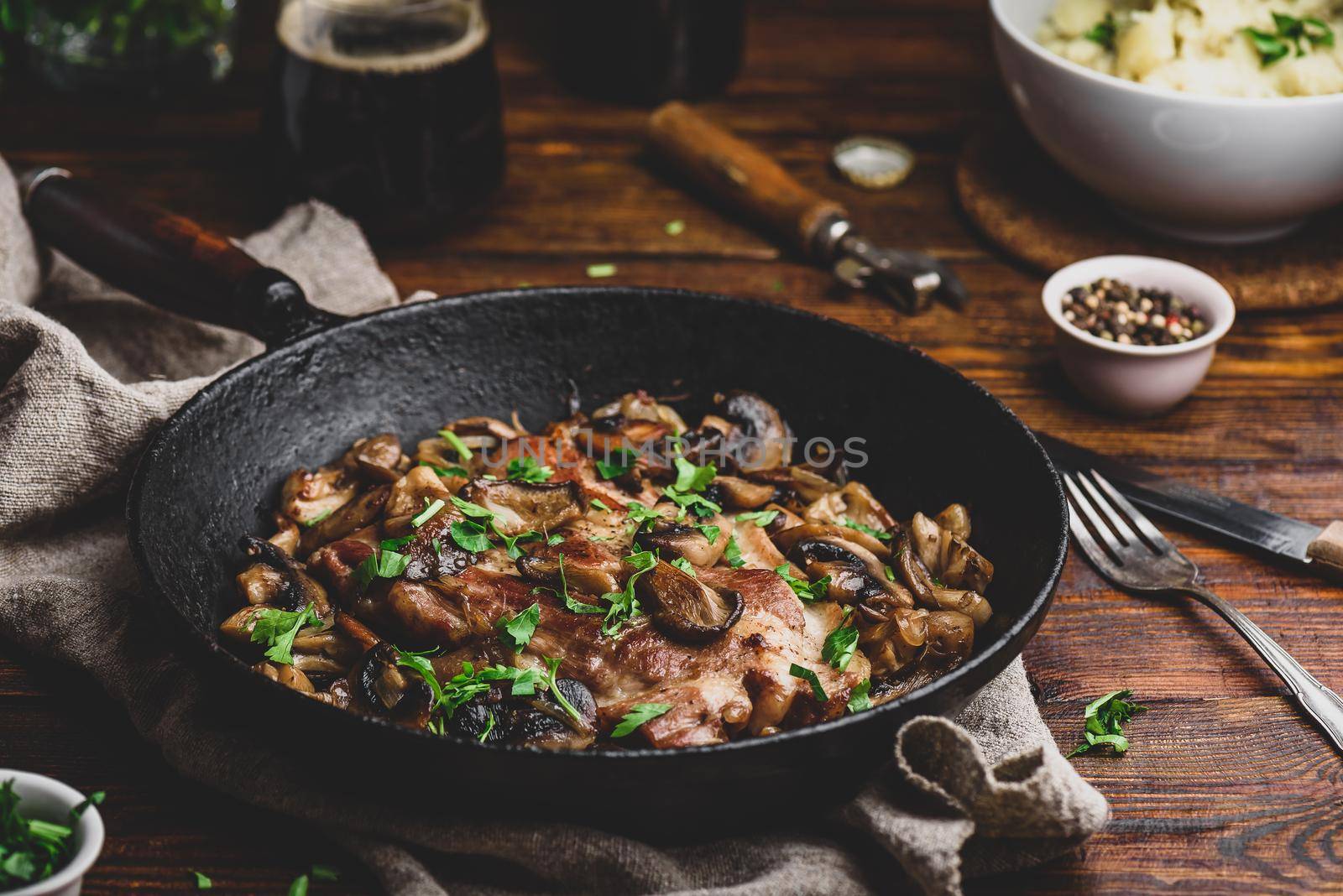 Fried pork neck steak with different mushrooms cast iron pan