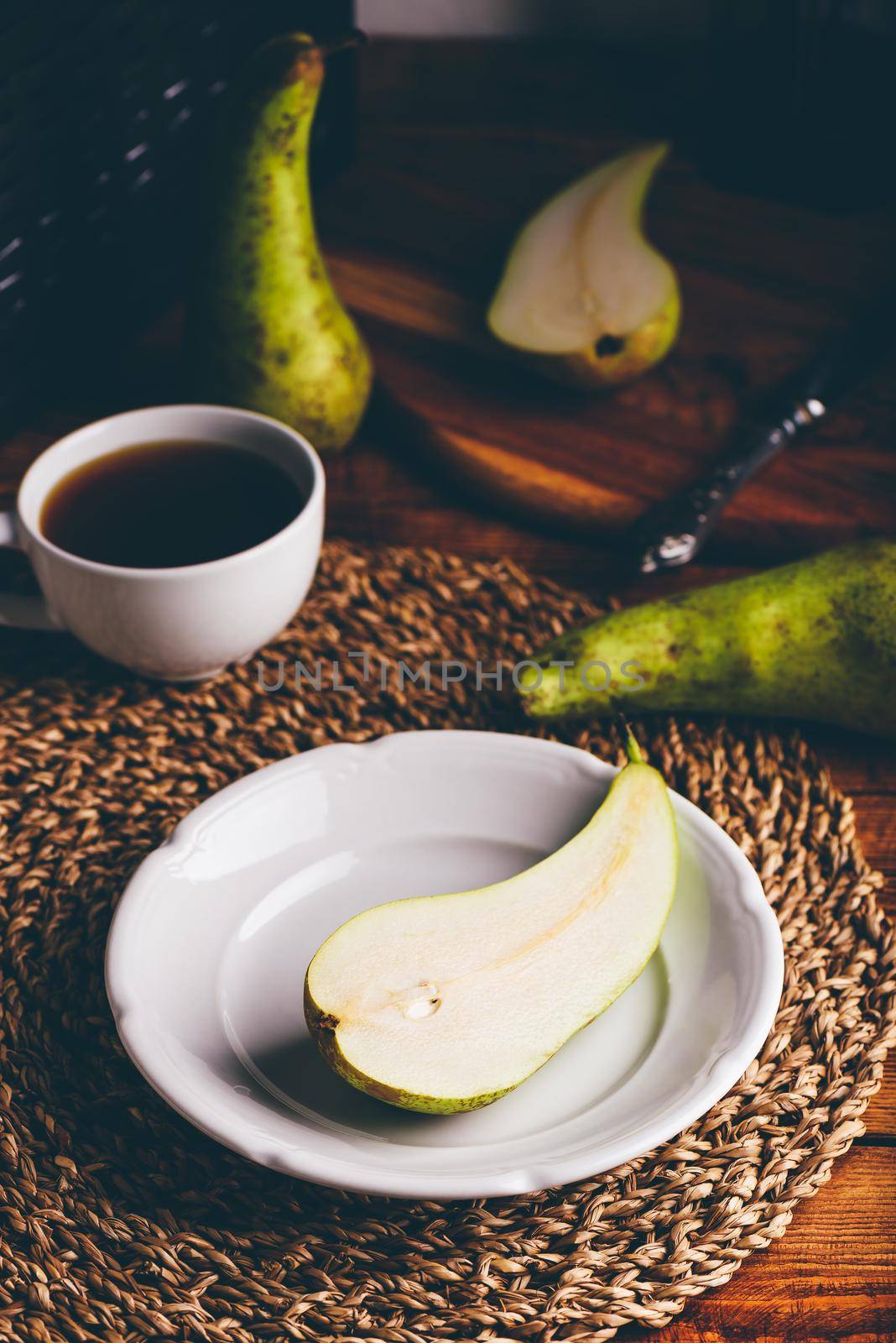 Half of Green Pear on White Plate and Cup of Coffee