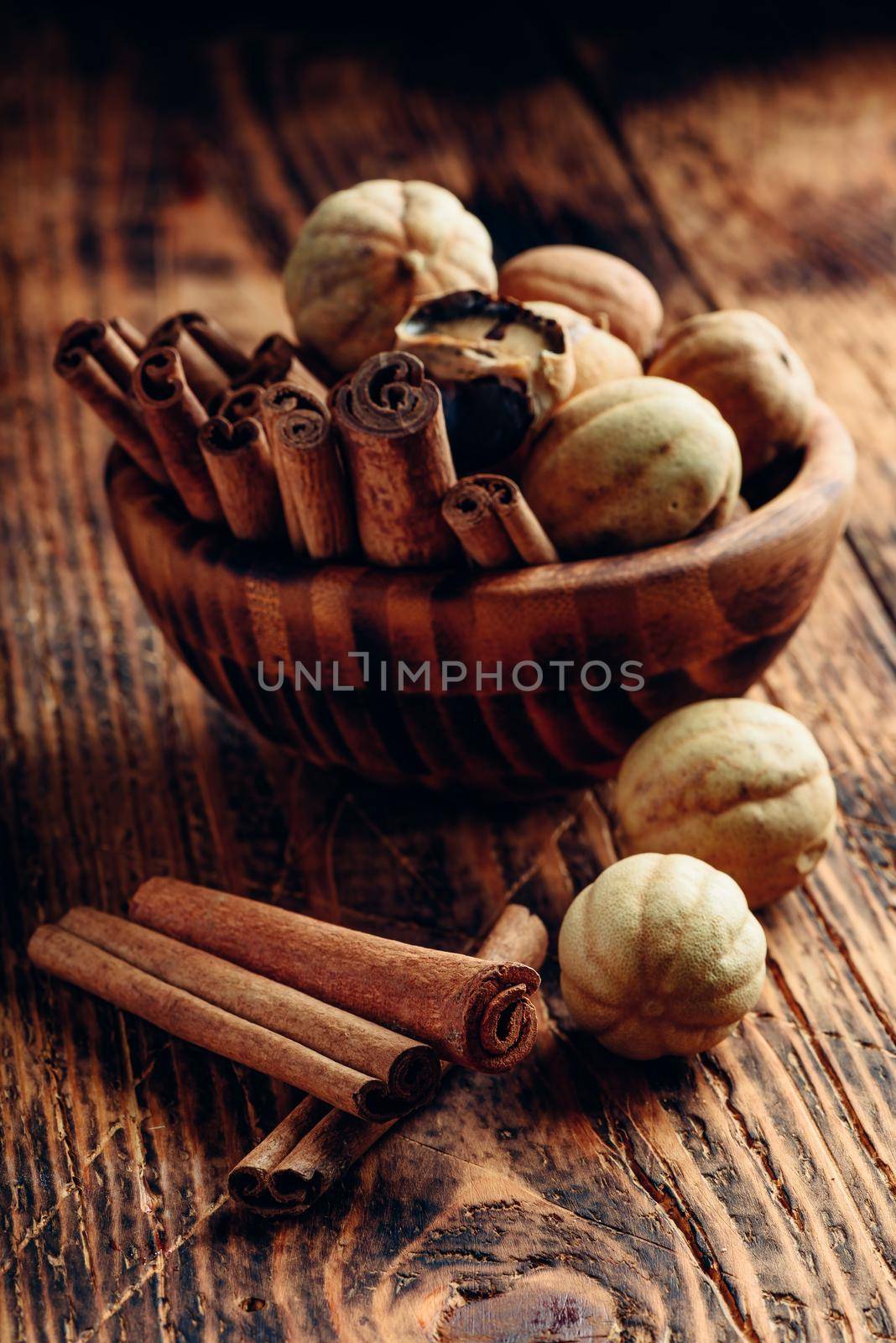 Cinnamon sticks and dried limes in wooden bowl by Seva_blsv
