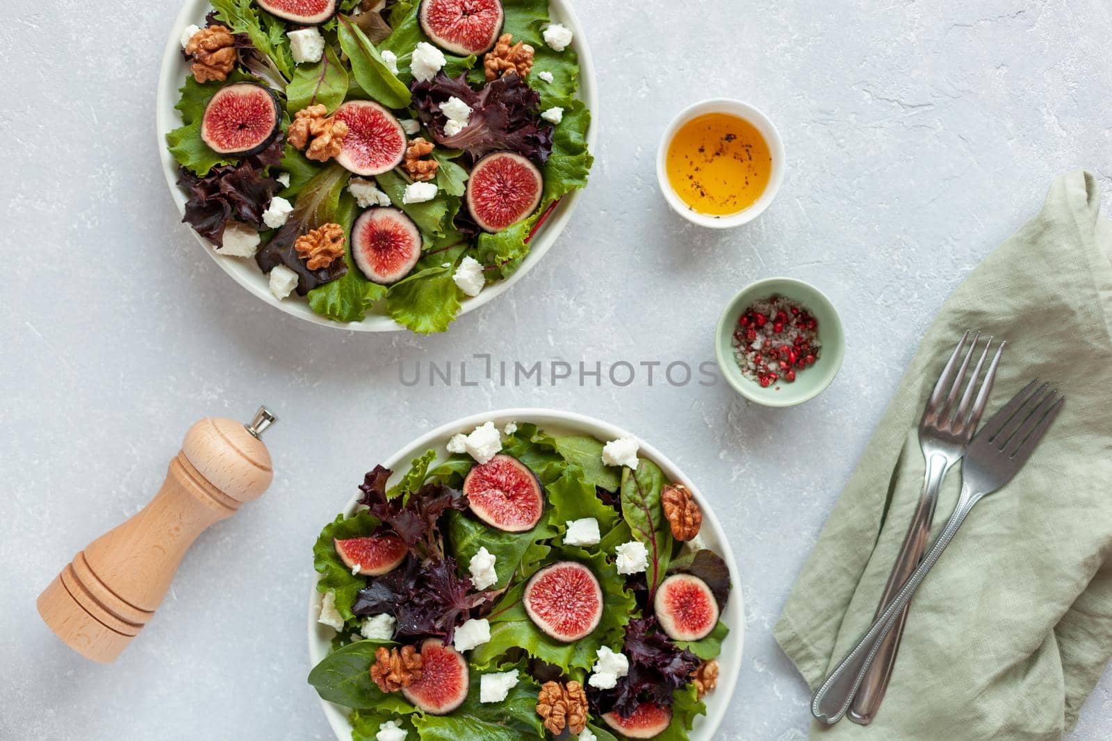 two portion of fig, salad leaves, feta and walnuts salad, overhead