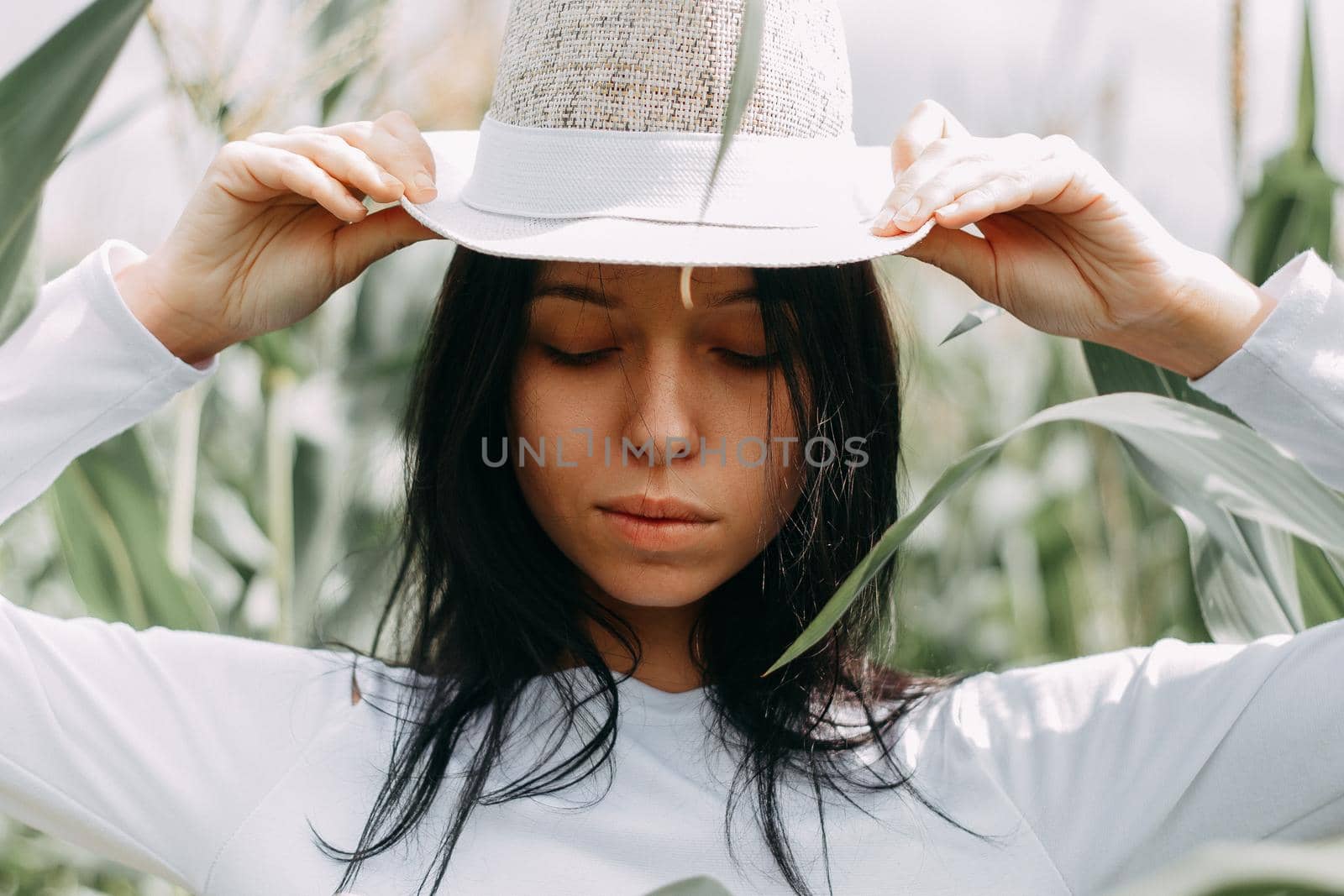 A brunette girl in a white dress in a cornfield. The concept of harvesting by Annu1tochka