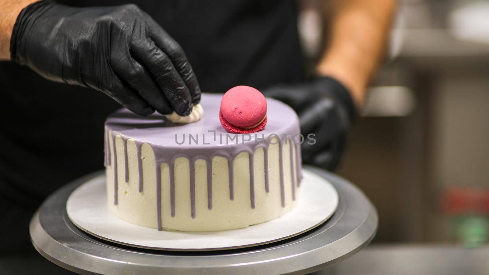chef usign macaron , flowers and text sign for a celebration cake
