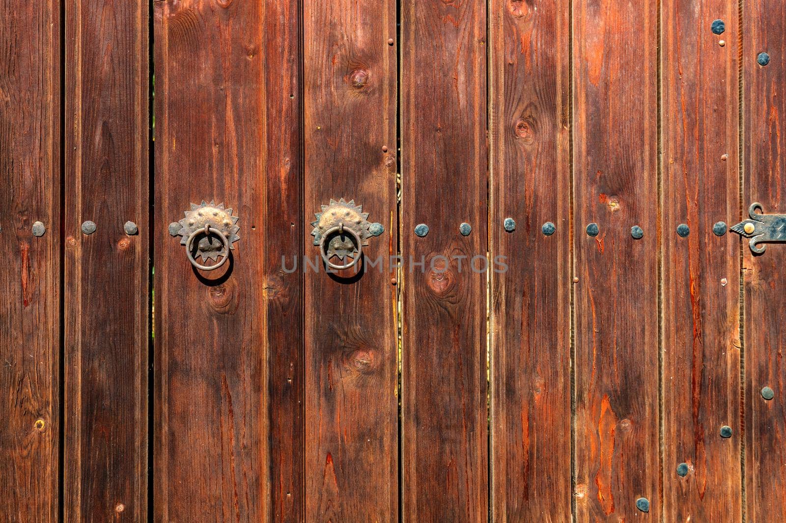 Old vintage wooden door ornate with a beauty metal furniture. Close up
