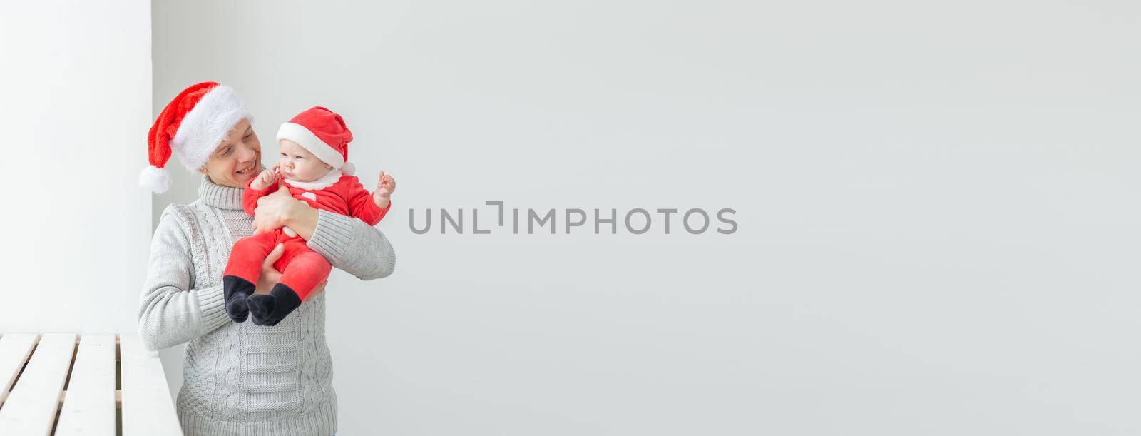 Banner fatherhood and holidays concept - Father with his baby boy wearing Santa hats celebrating Christmas by Satura86