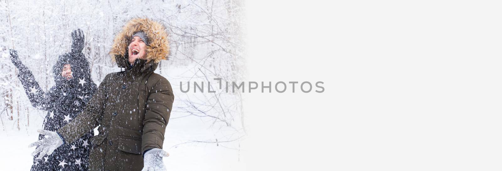 Banner happy young couple throw up a snow in a winter forest copy space by Satura86