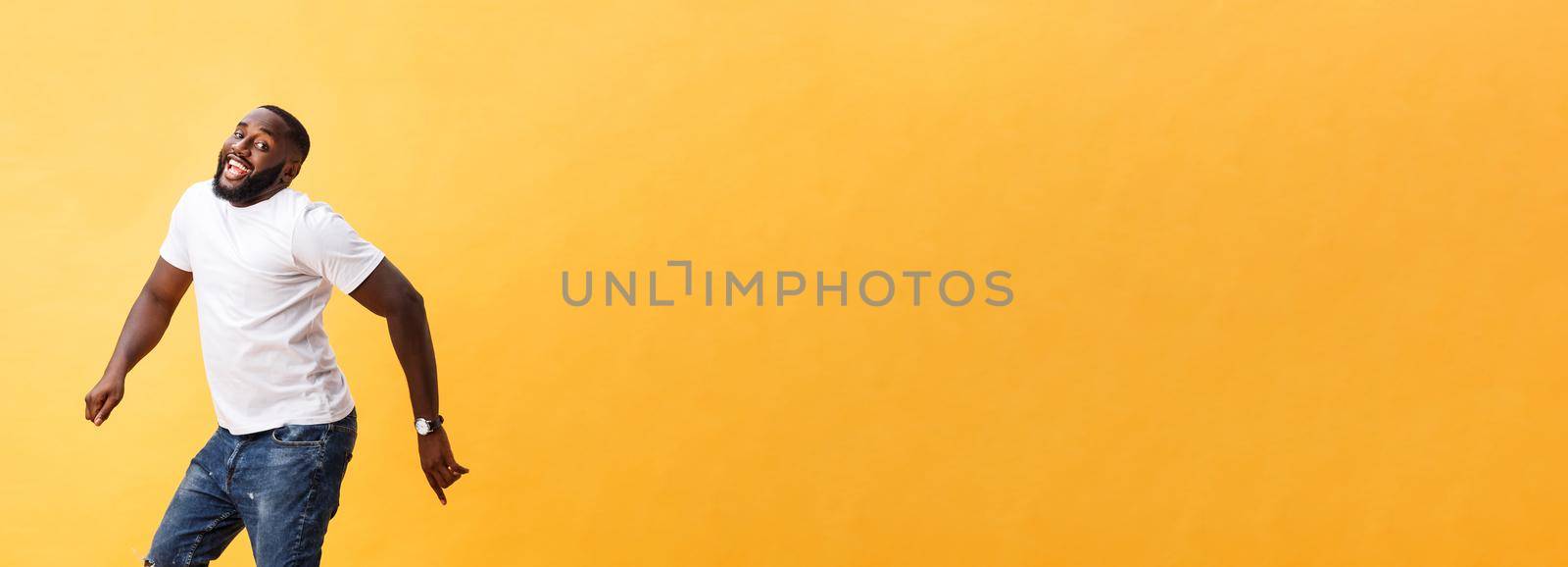 Full length of handsome young black man jumping against yellow background