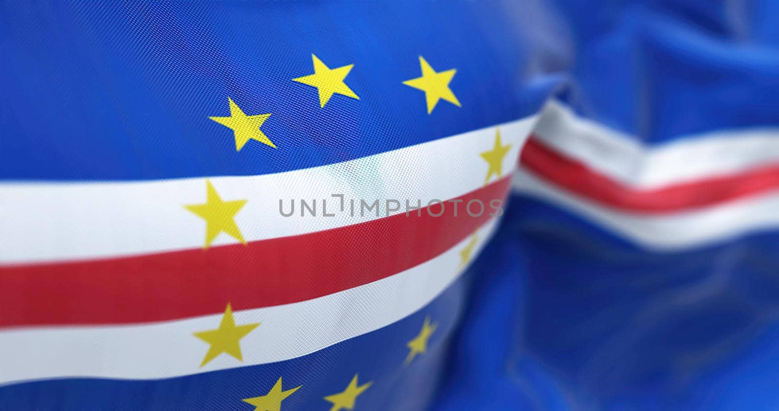 Close-up view of the Cape Verde national flag waving in the wind. The Republic of Cabo Verde, is an island country in the central Atlantic Ocean. Fabric textured background. Selective focus