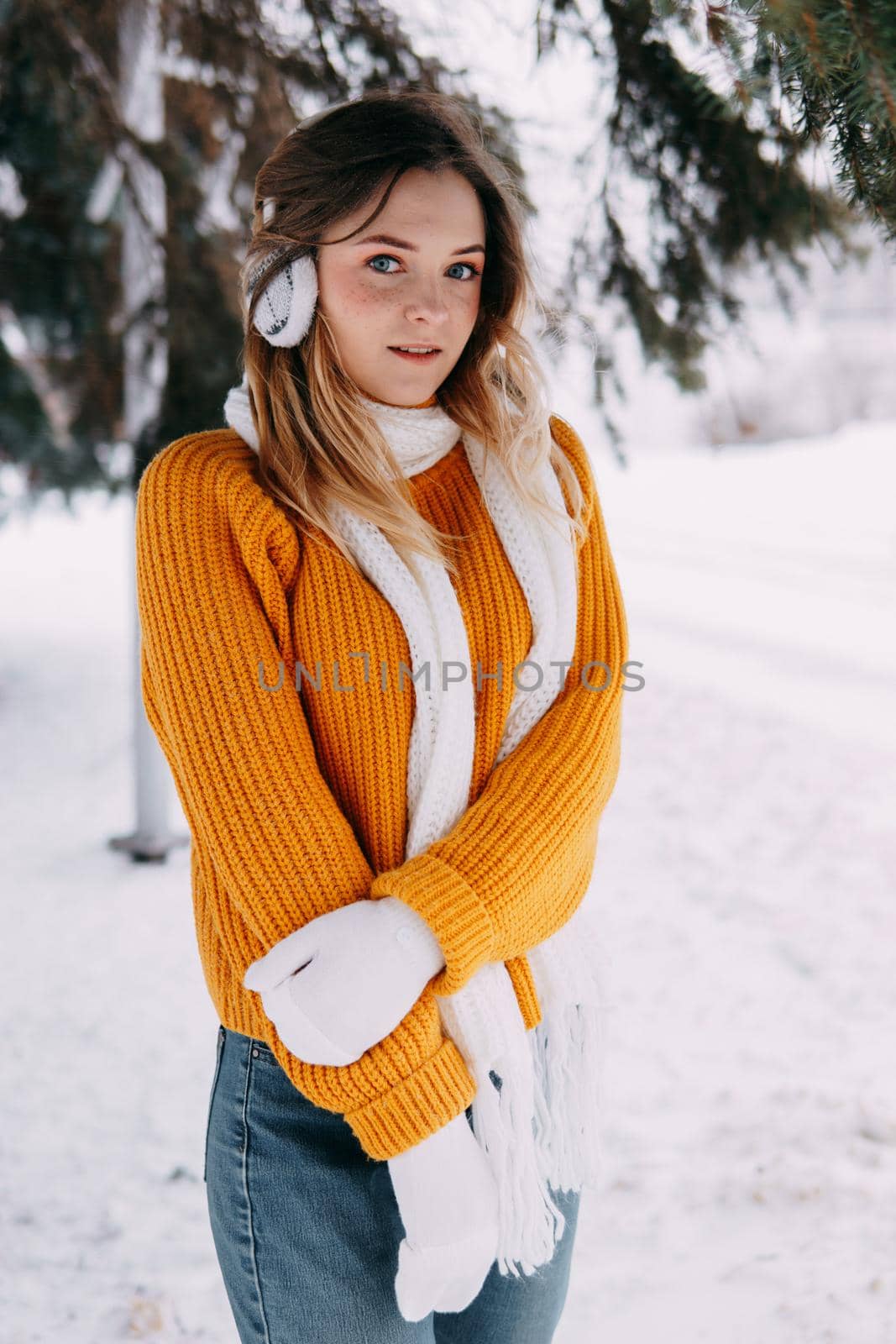 Teen blonde in a yellow sweater outside in winter. A teenage girl on a walk in winter clothes in a snowy forest by Annu1tochka