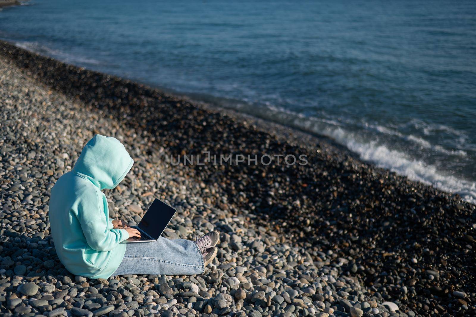 Caucasian woman working freelance on laptop on the beach. by mrwed54