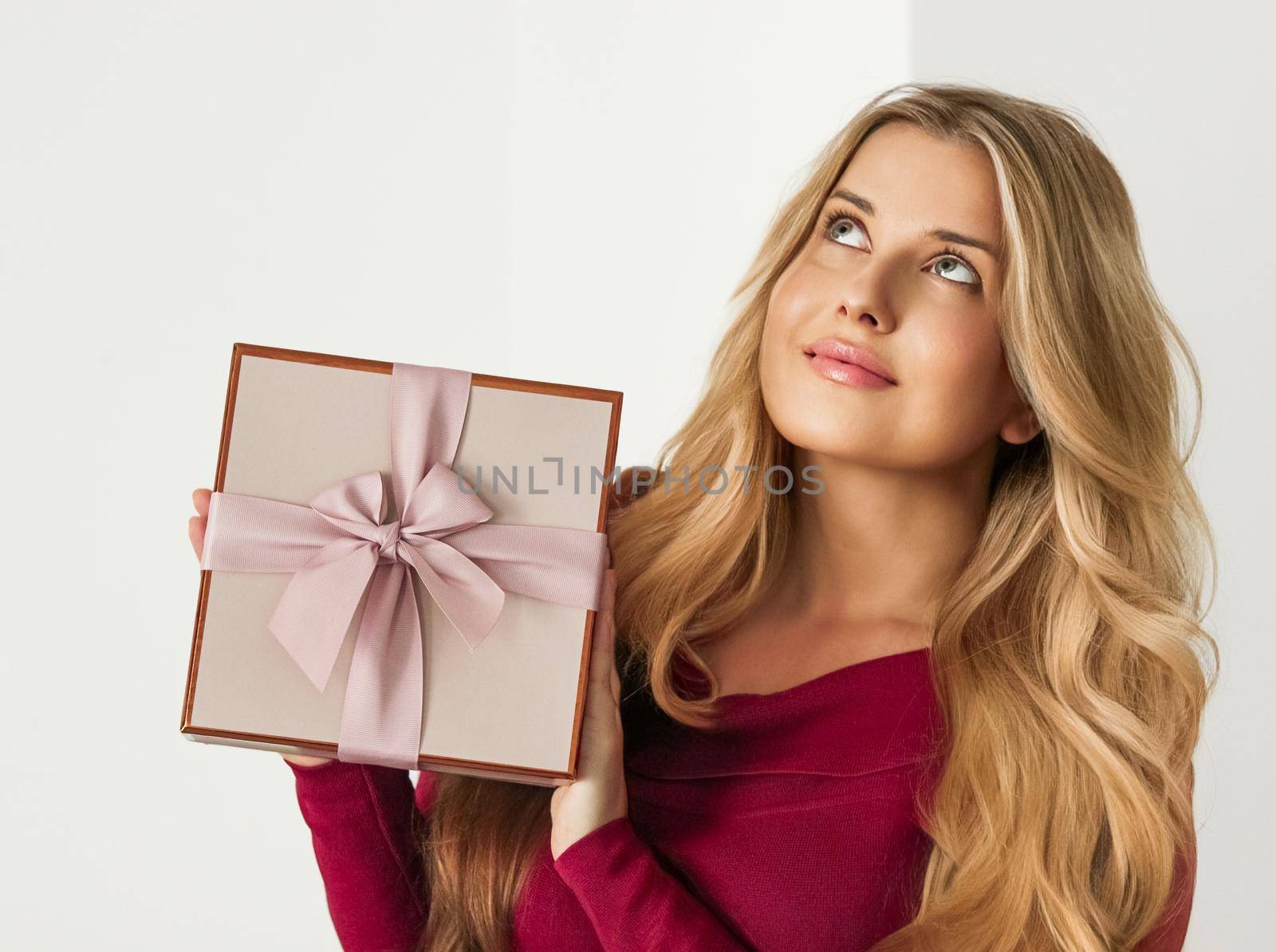 Holiday present for birthday, baby shower, wedding or luxury beauty box subscription delivery, happy woman holding a wrapped pink gift on white background