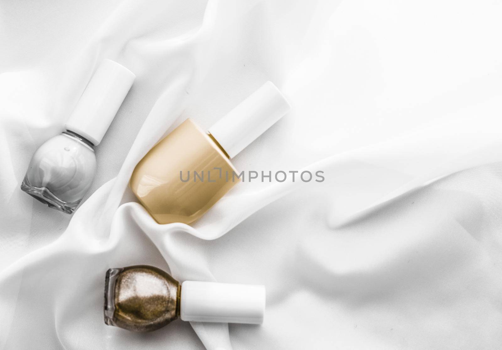 Cosmetic branding, salon and glamour concept - Nail polish bottles on silk background, french manicure products and nailpolish make-up cosmetics for luxury beauty brand and holiday flatlay art design