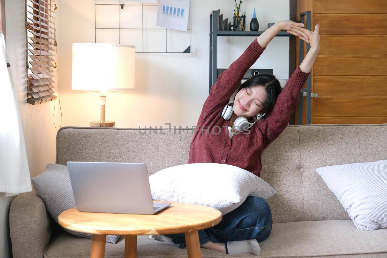 Young asian woman happy life sitting on couch cozy living room at home. The house was homely concept by wichayada
