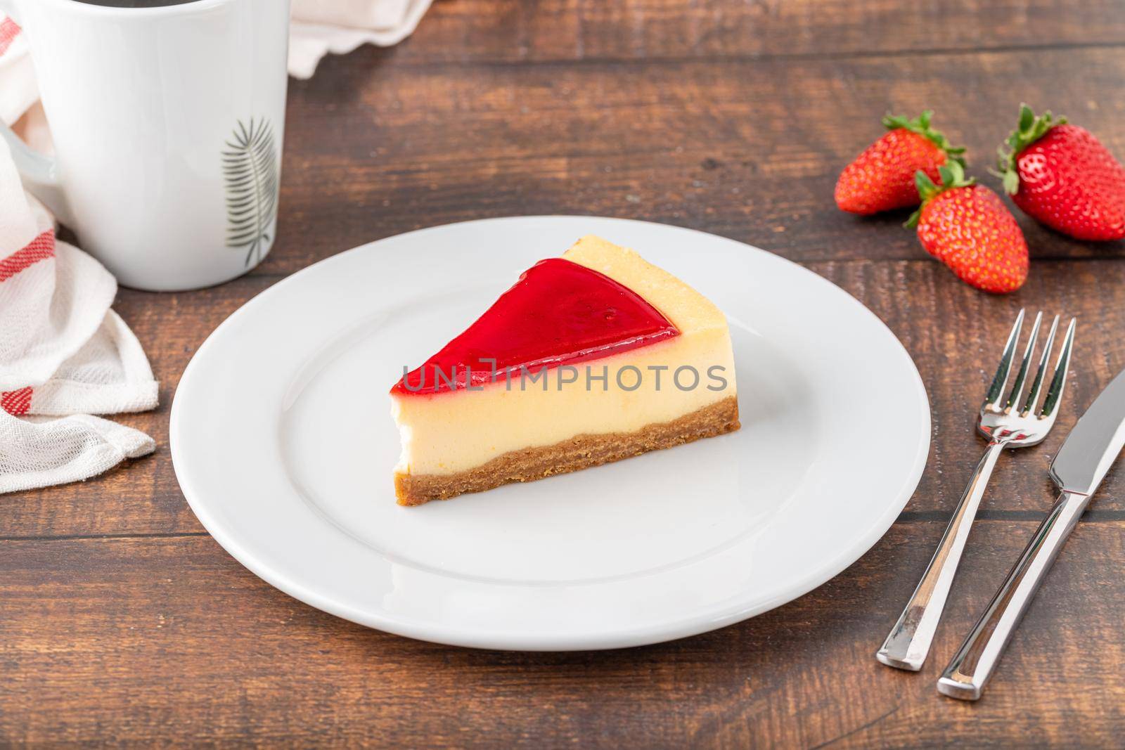 Delicious strawberry cheesecake with coffee next to it on wooden table by Sonat