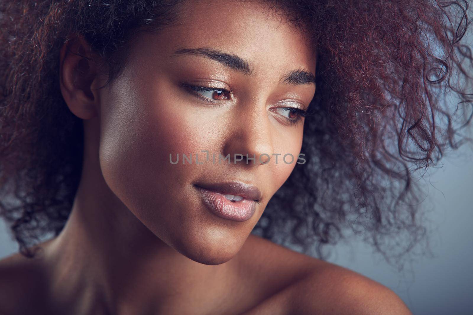 Natural gorgeous curls. Head and shoulders shot of a beautiful african woman with curly hair. by YuriArcurs