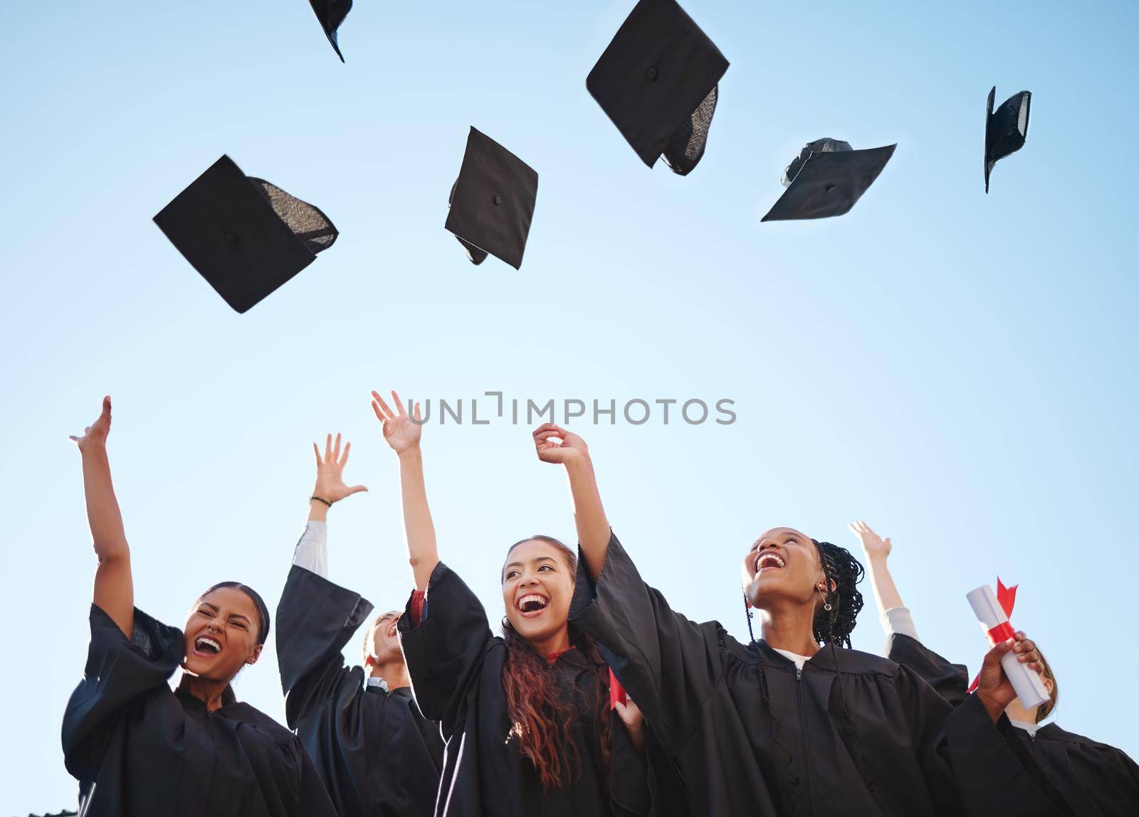 Graduation cap, student and graduate class happy at a diploma and education success ceremony. University or college students and friends with happiness smile proud of certificate achievement by YuriArcurs