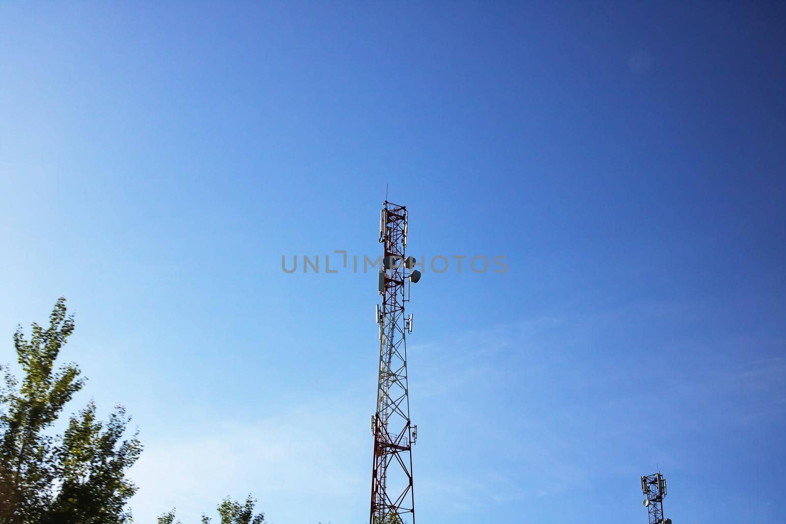 Pole with electric pipelines in a field and blue sky