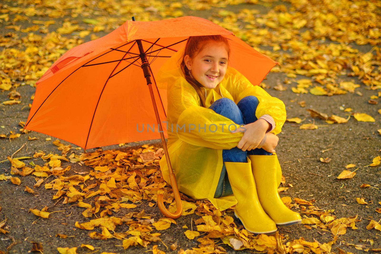 Happy kid Sits in the autumn park by InnaVlasova