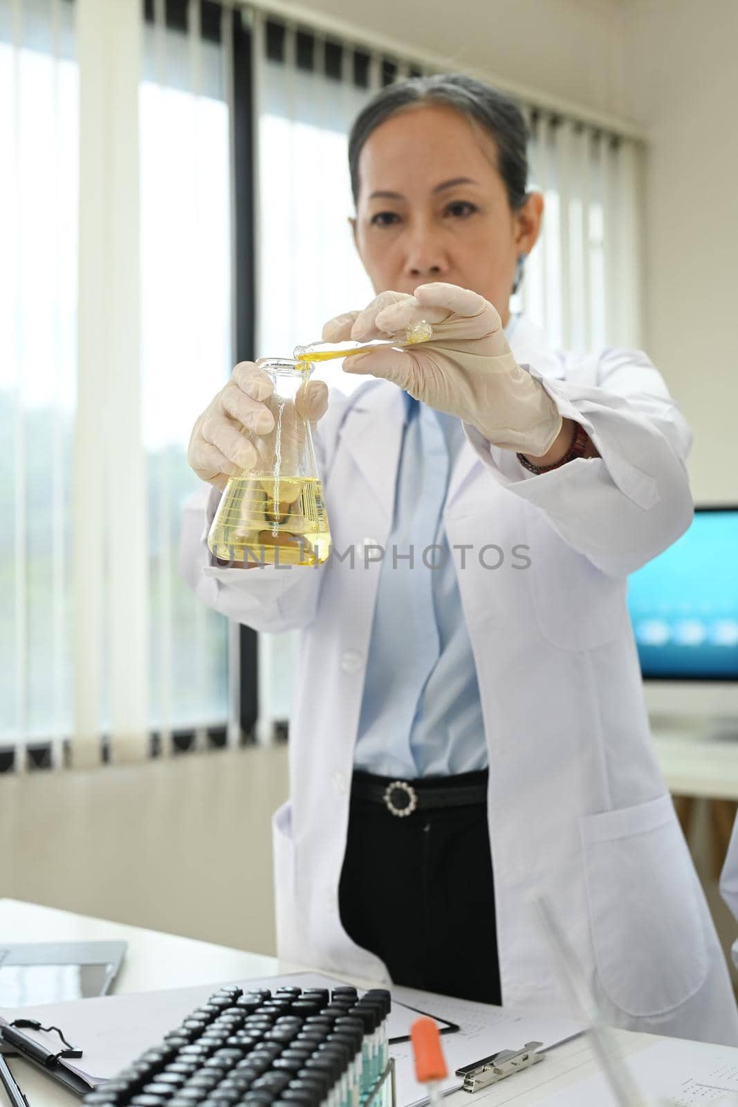 Professional scientists team conducting experiment in modern laboratory. Medicine and science researching concept.