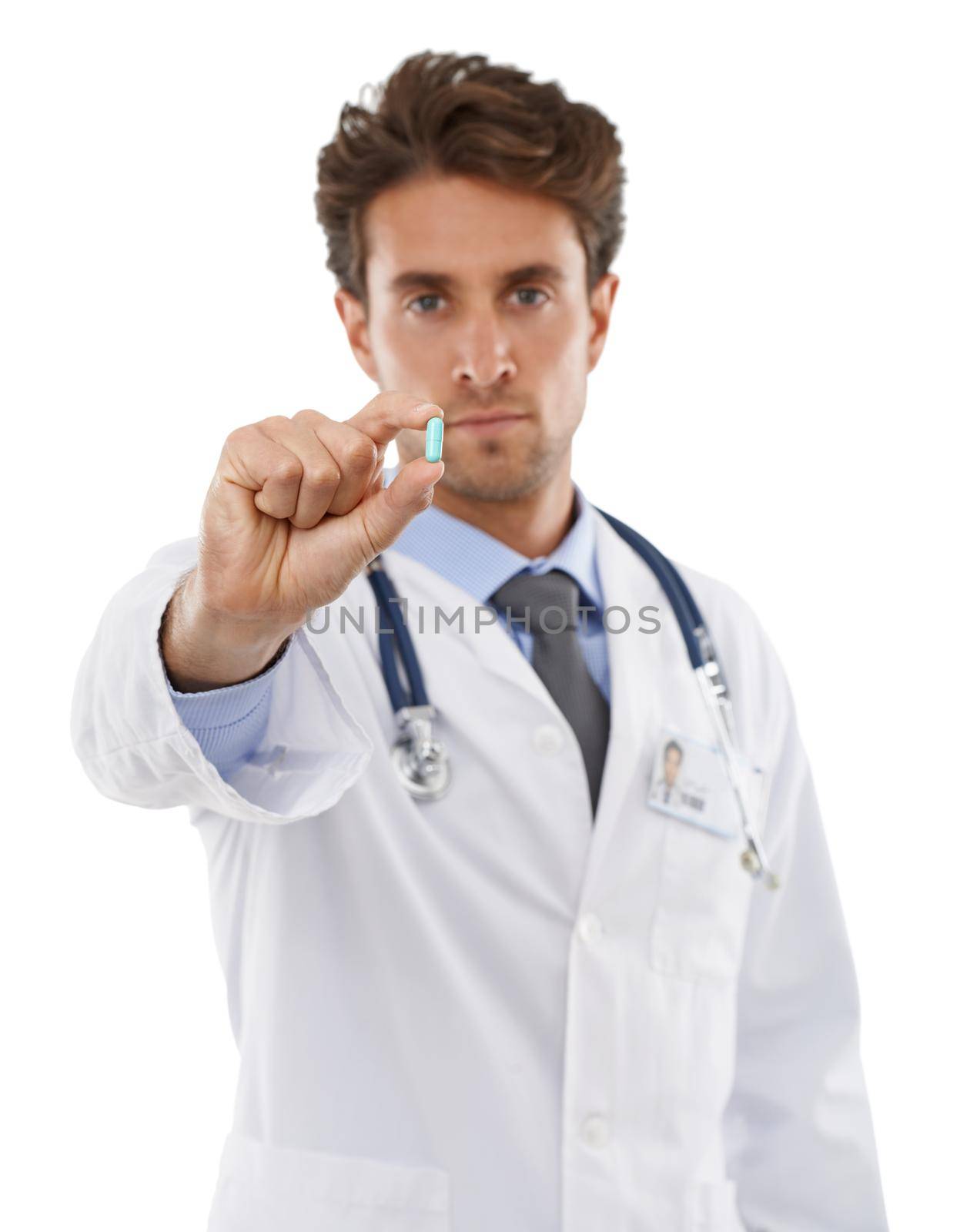 Take this two times daily. Studio shot of a serious-looking young doctor holding a pill up to the camera