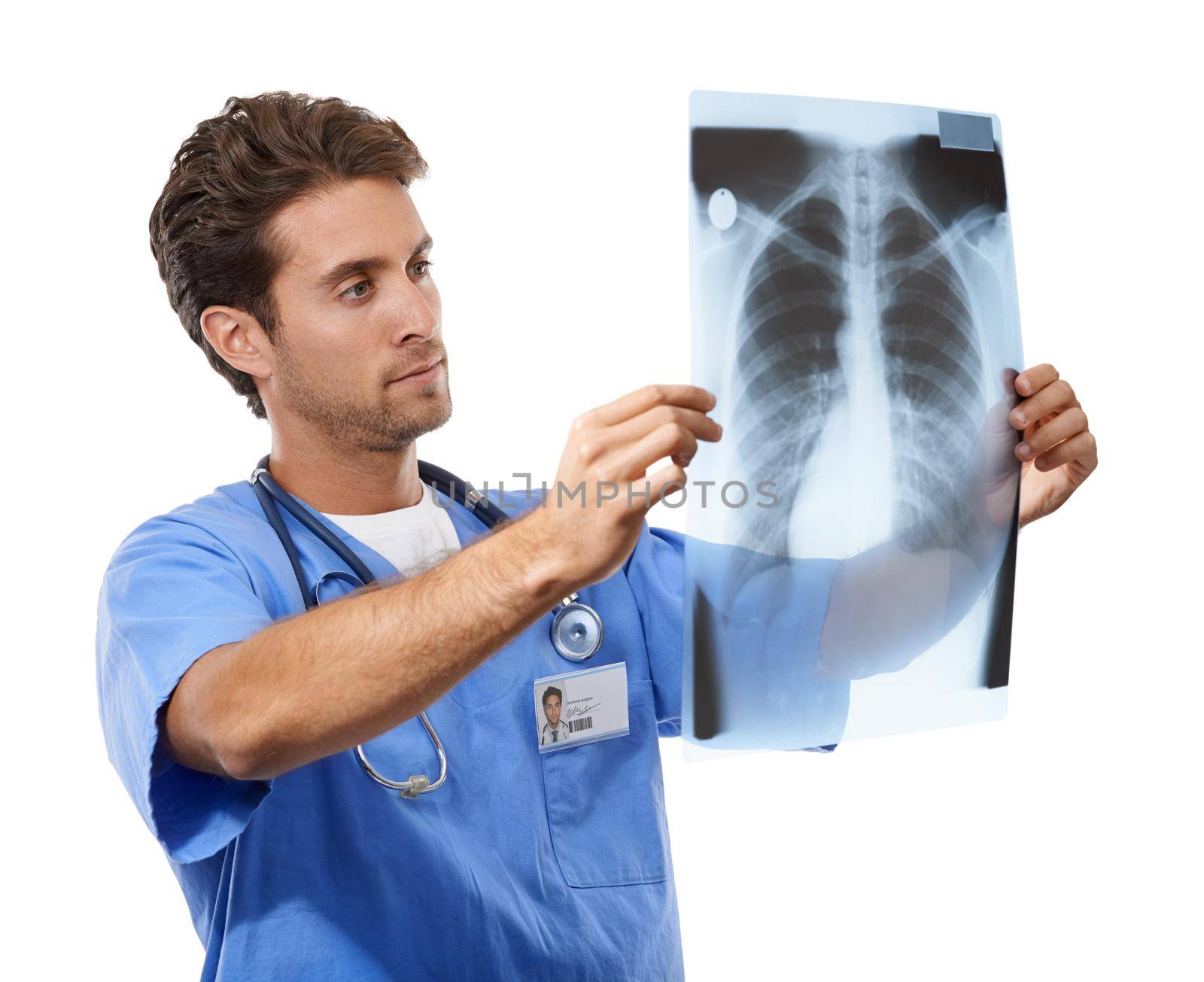 Focusing on finding a treatment. Studio shot of a handsome young doctor examining an x-ray he is holding up. by YuriArcurs