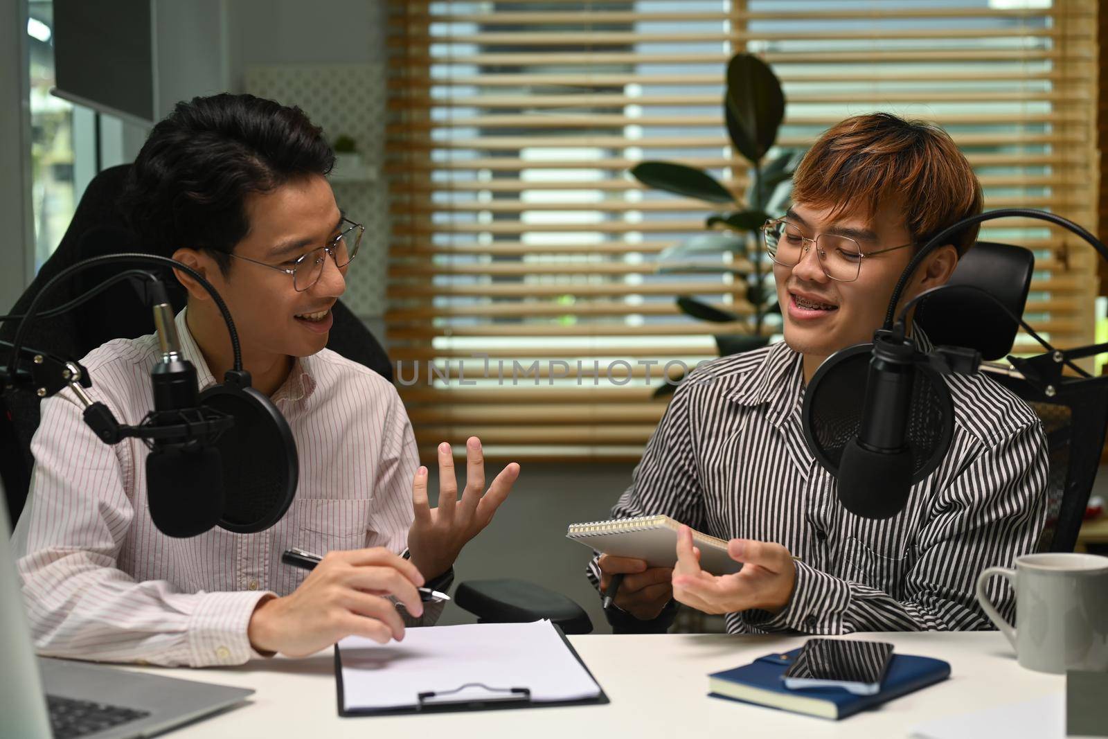 Image of radio host using microphone and laptop to recording podcast in home studio. Radio, podcasts and technology concept.