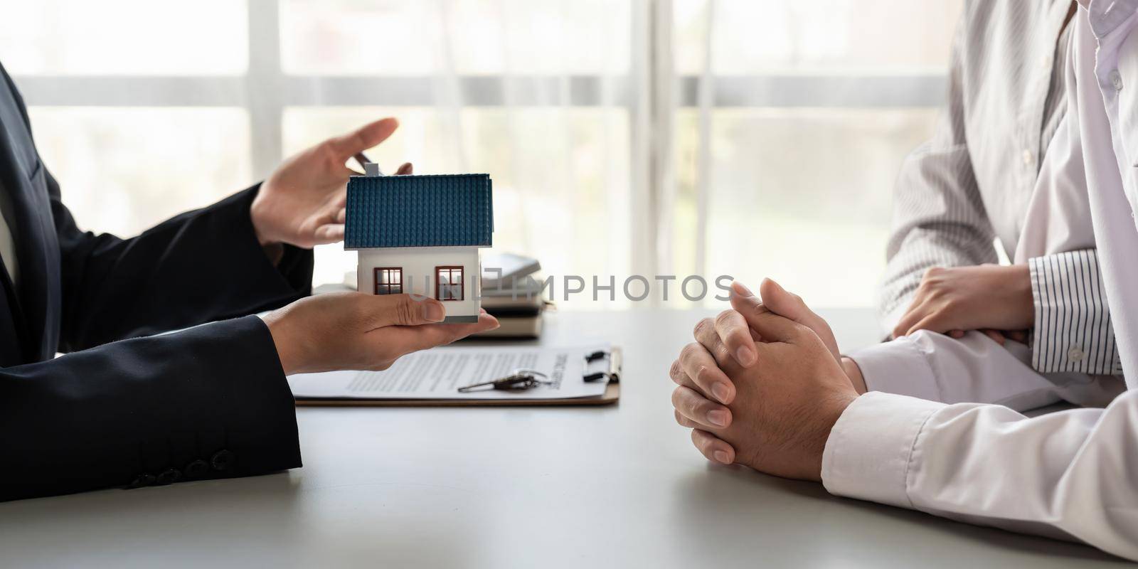 Real estate agent presenting to a couple a project property house model