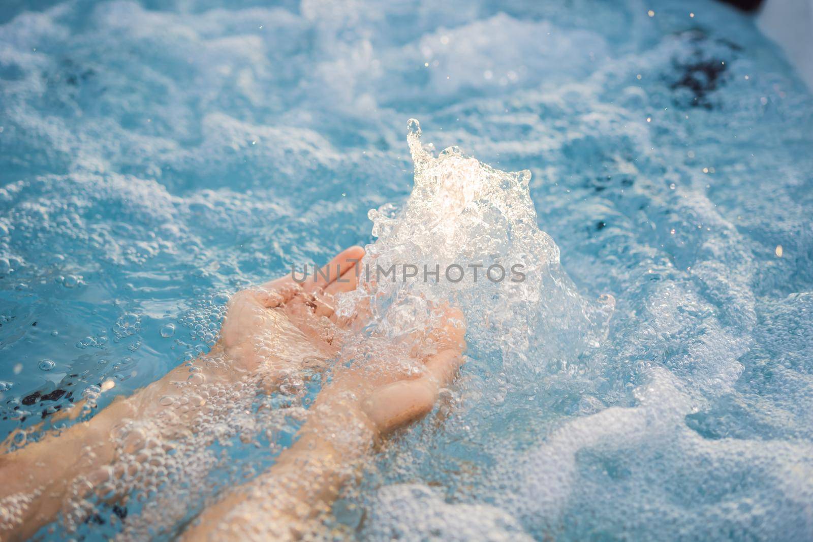 Portrait of young carefree happy smiling woman relaxing at hot tub during enjoying happy traveling moment vacation life against the background of green big mountains.