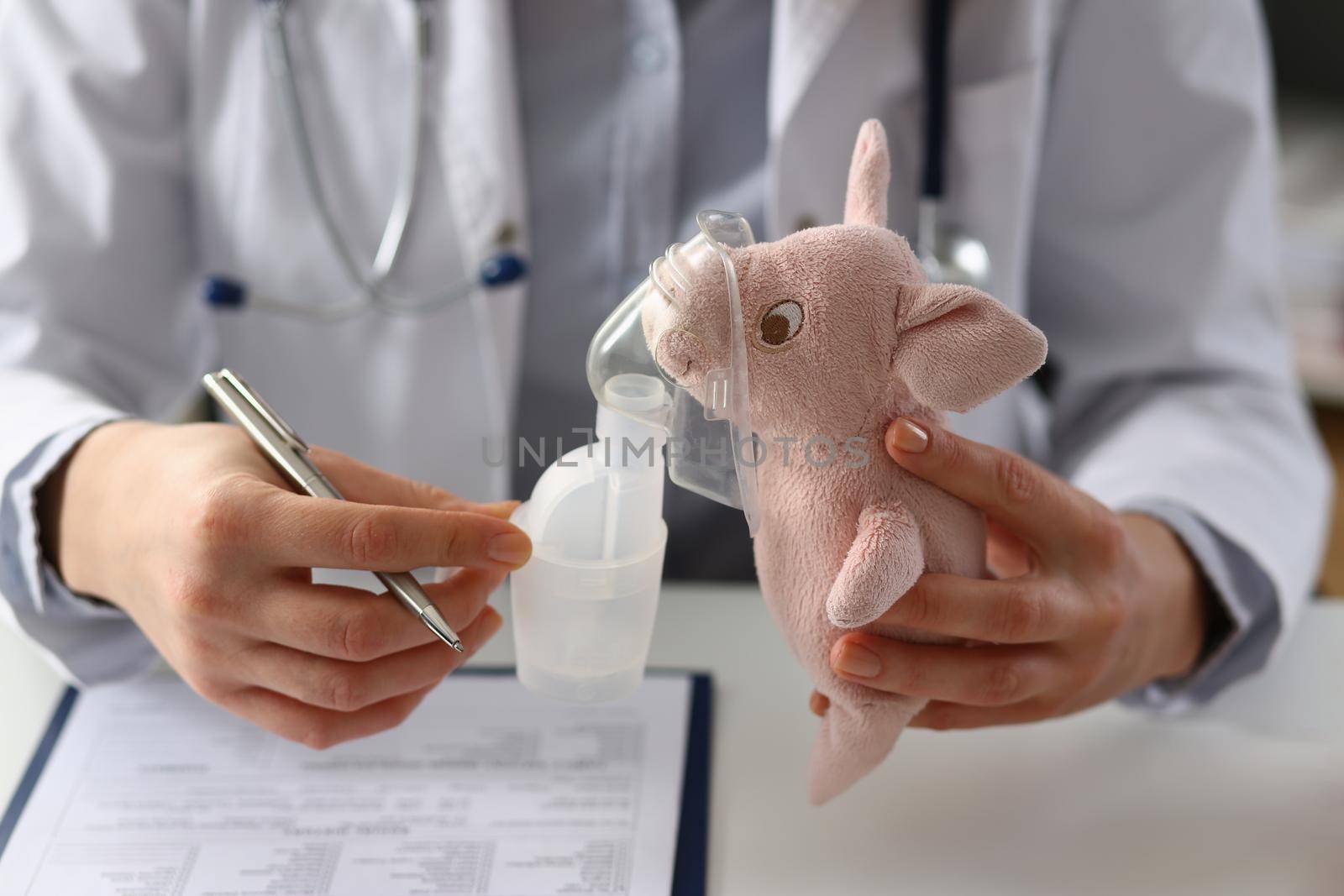 Doctor holds toy with oxygen mask in clinic. Nebulizer for children concept