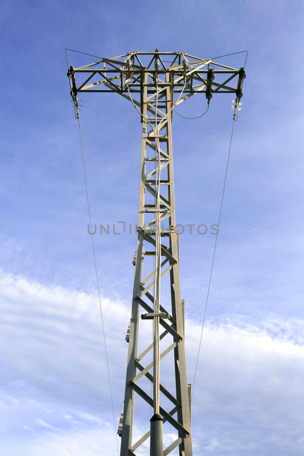 Power lines tower under blue sky in the countryside in Spain