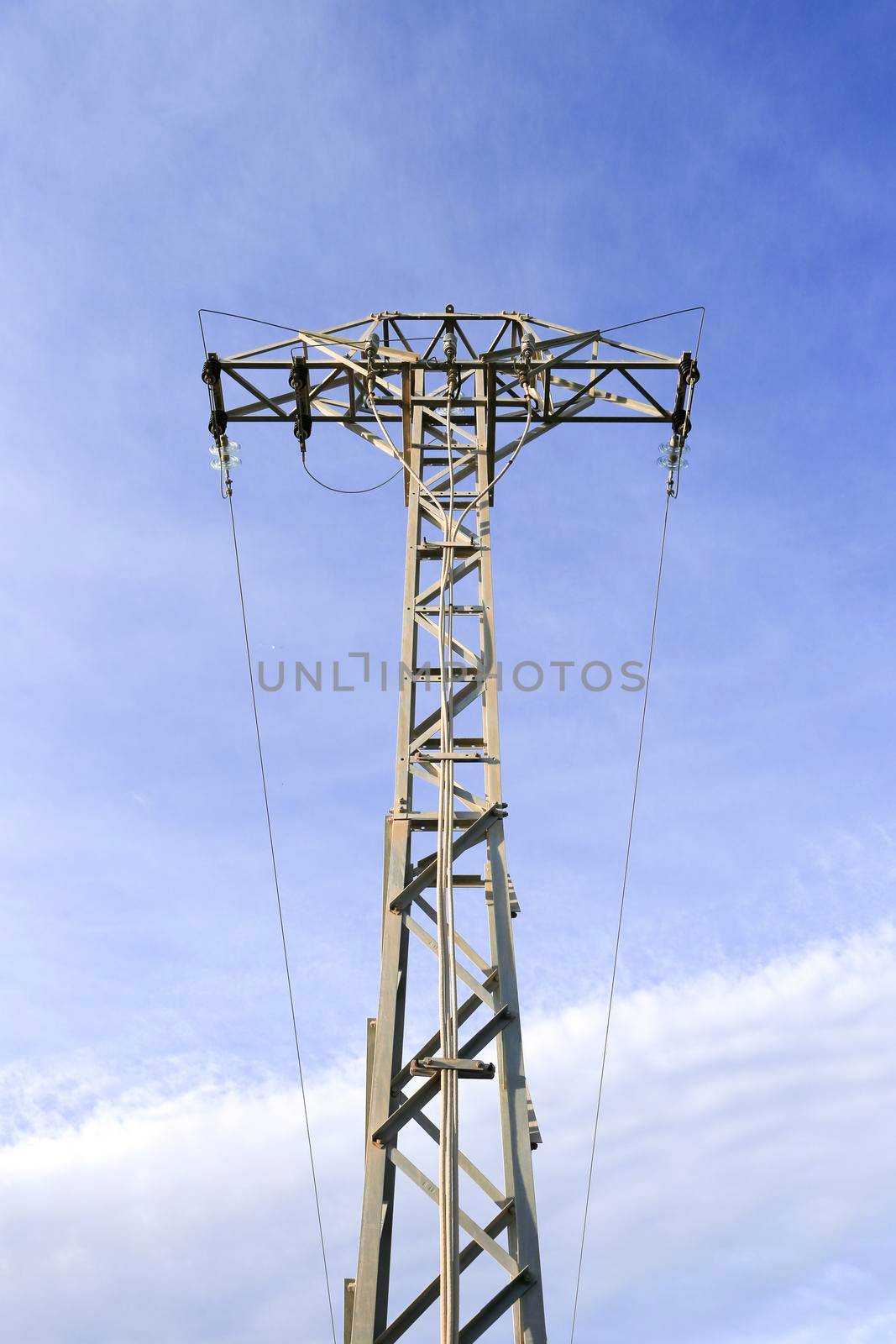 Power lines tower under blue sky in the countryside in Spain