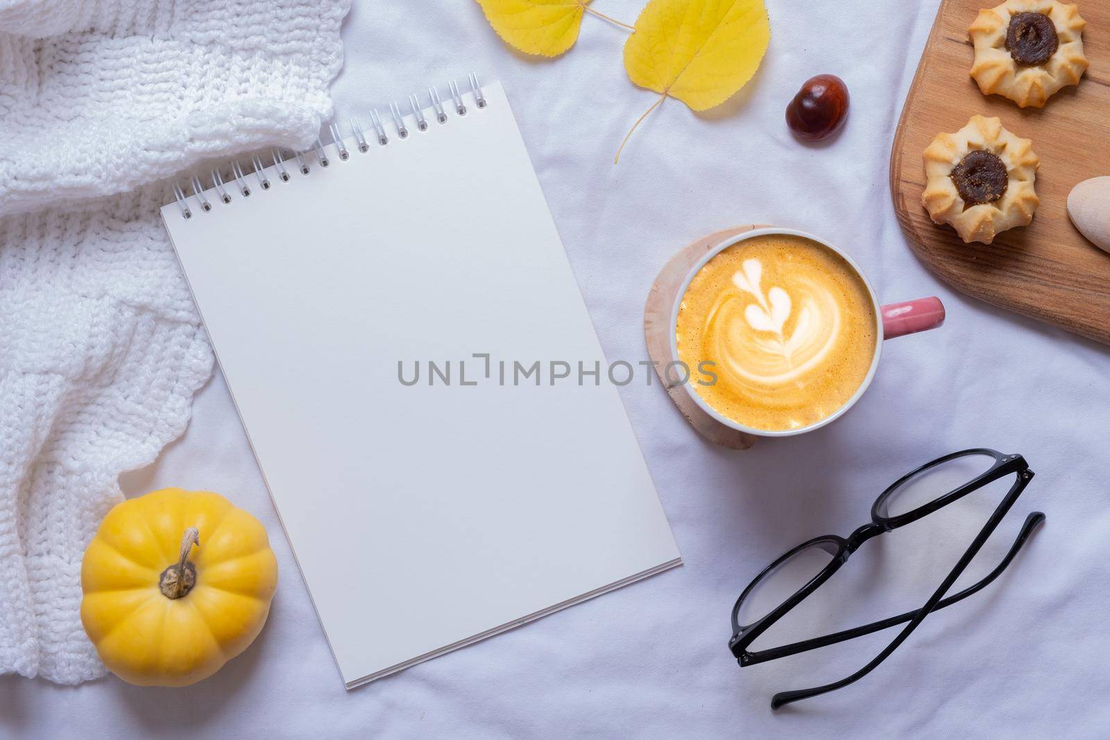 Blank sheet of paper and autumn cozy decor with latte top view. Copy space for autumn text by ssvimaliss