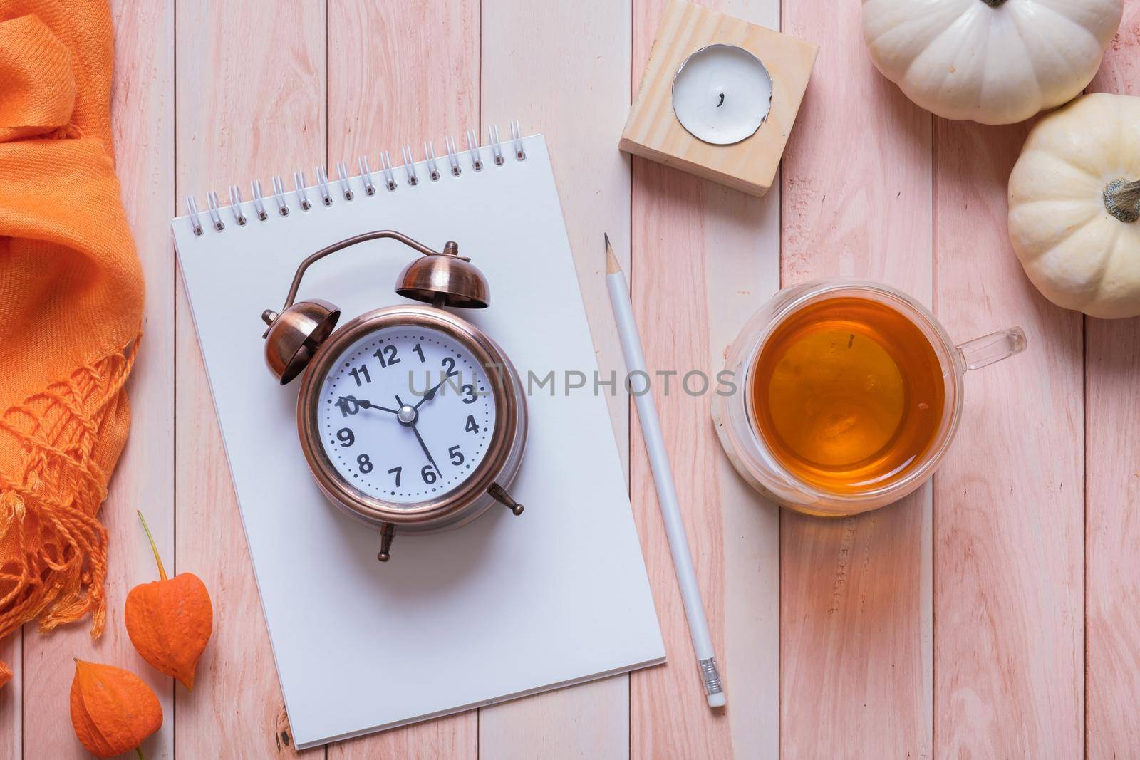 Time Change concept with autumn cozy decor top view on desktop with alarm clock and laptop. Fall back concept. by ssvimaliss