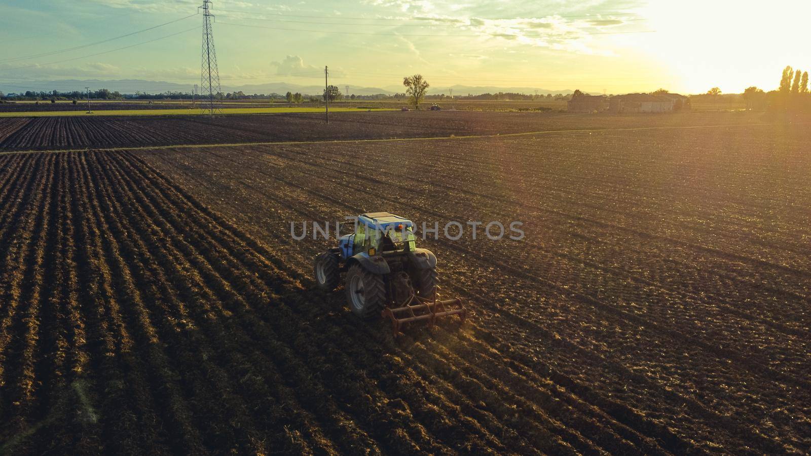 farmer with tractor leveling land in the countryside.
