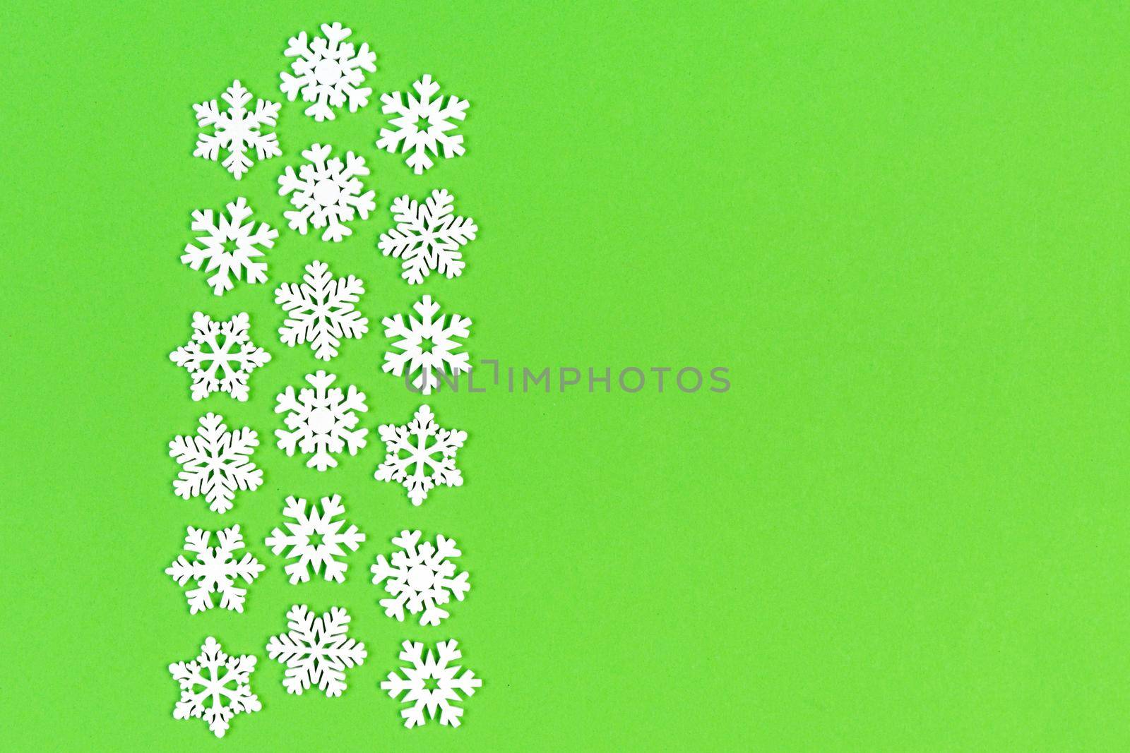 Top view of white snowflakes on colorful background. Winter weather concept with copy space. Merry Christmas concept.