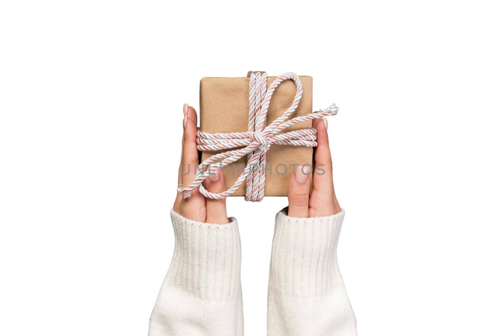 woman hands holding gift wrapped and decorated with pink bow isolated on white.