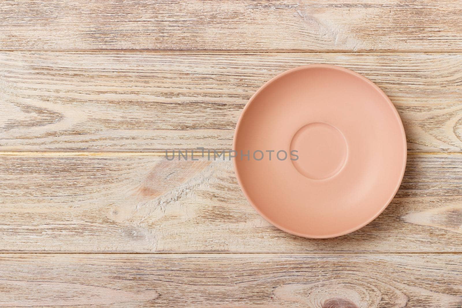 empty orange matte plate on wooden background.