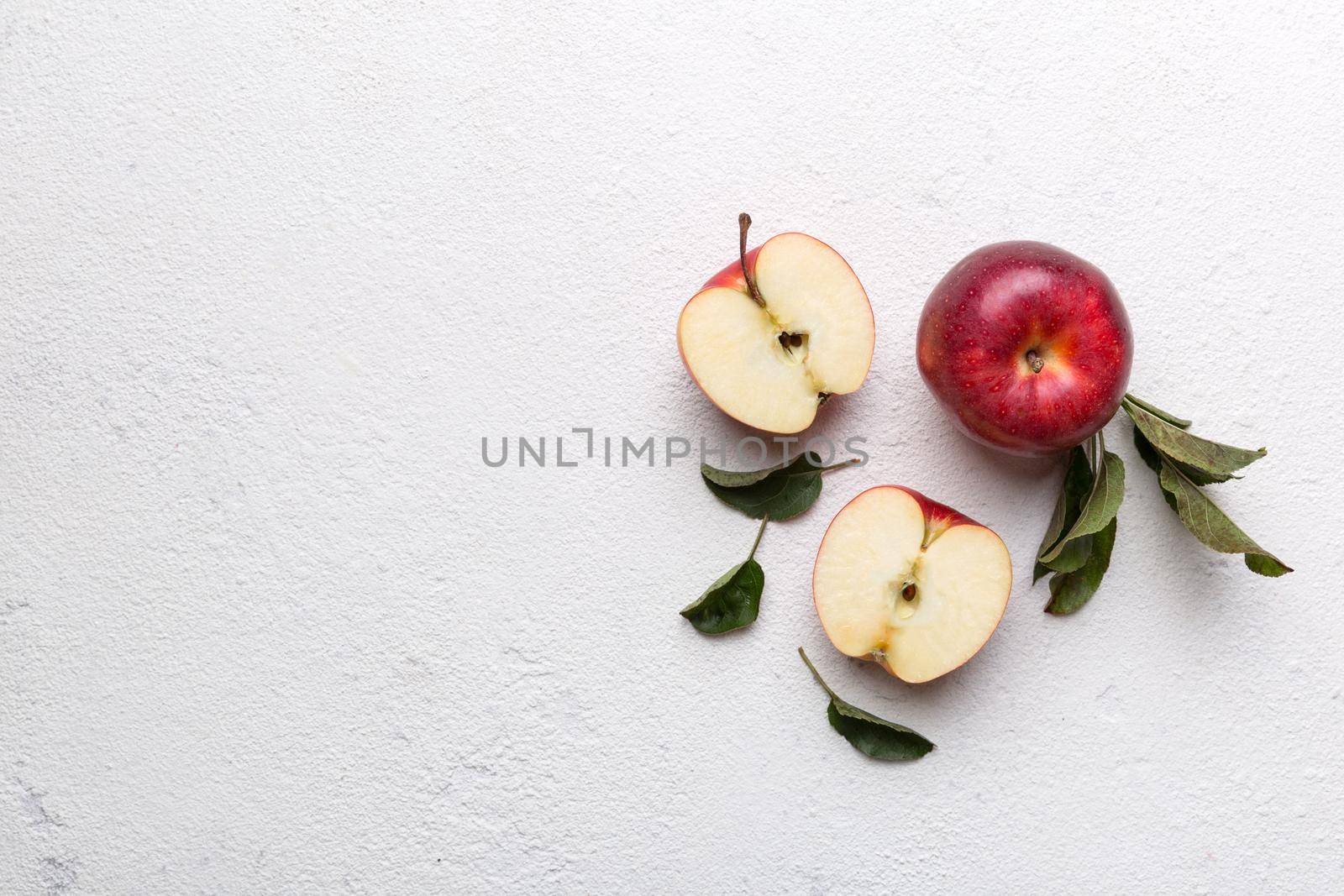 Fresh red apples with green leaves on wooden table. On wooden background. Top view free space for text.