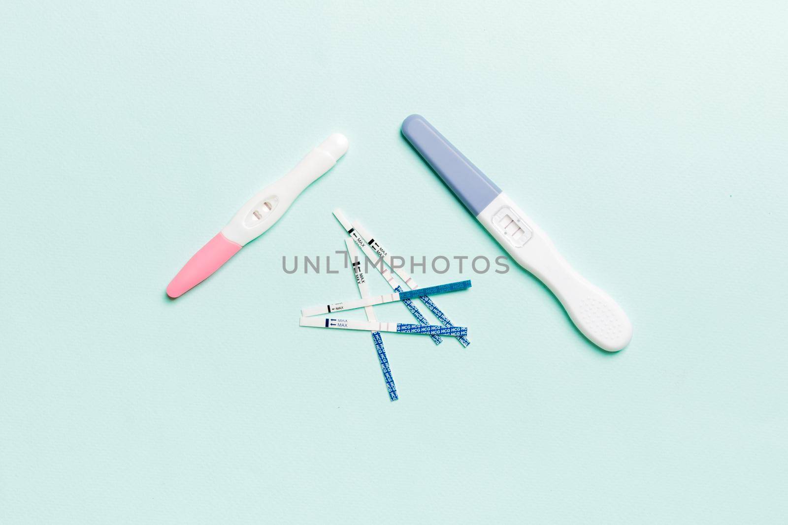 Colored Pregnancy test on colored background, top view with copy space.