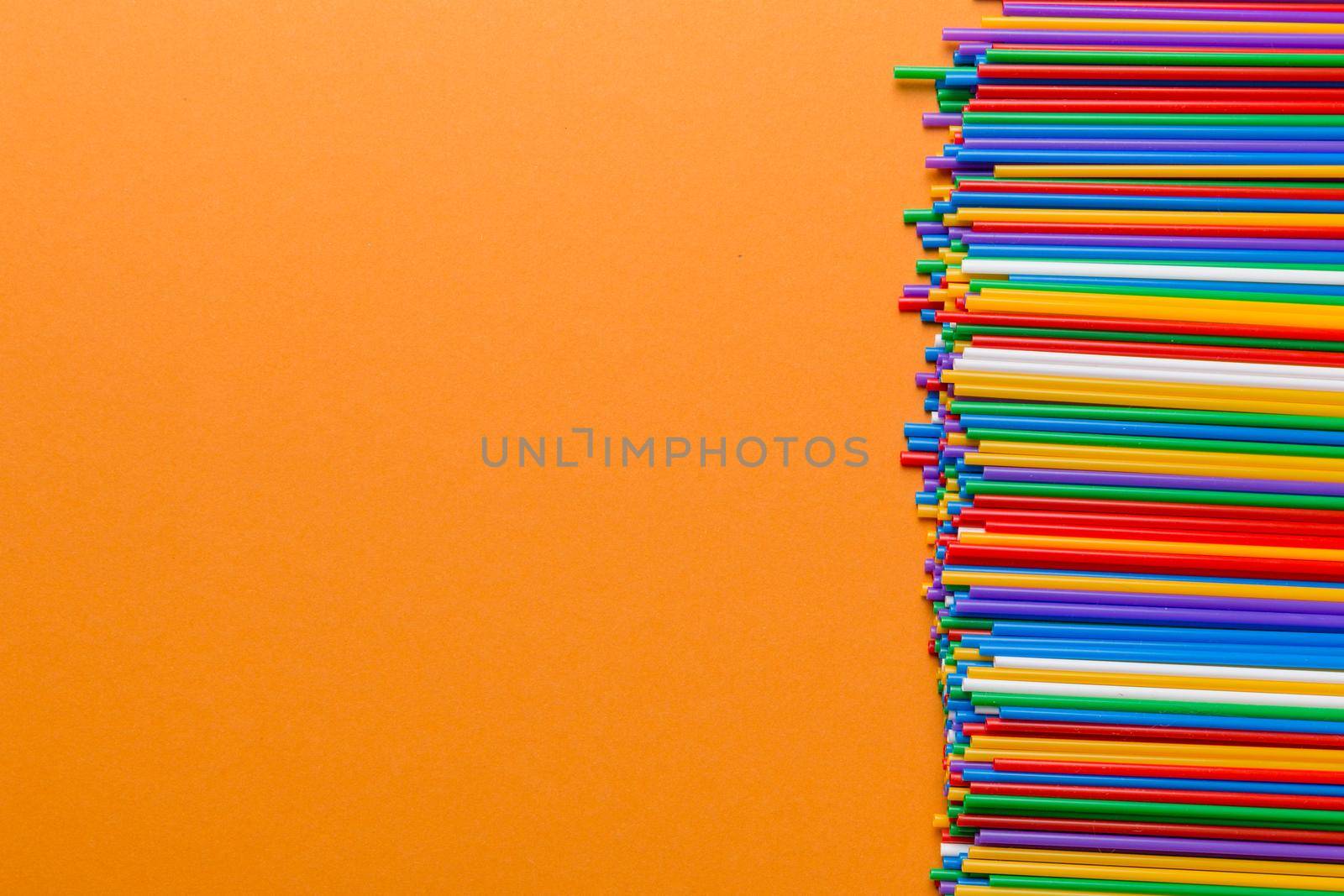 Heap of colorful plastic drinking straws on Colored background, flat lay. Copy Space for text by Snegok1967