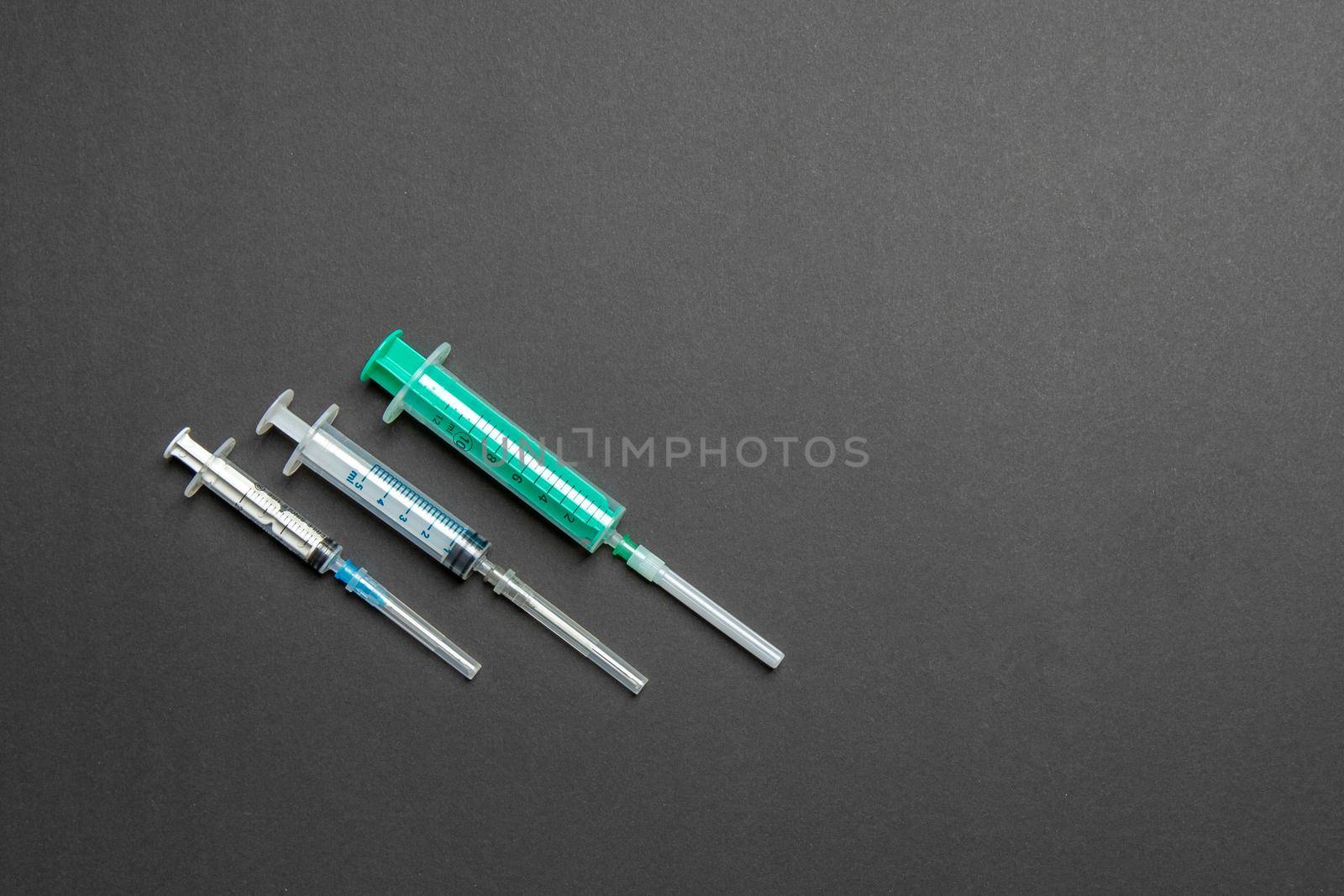 Top view of different syringes for injection on colorful background. Medical equipment concept with copy space.