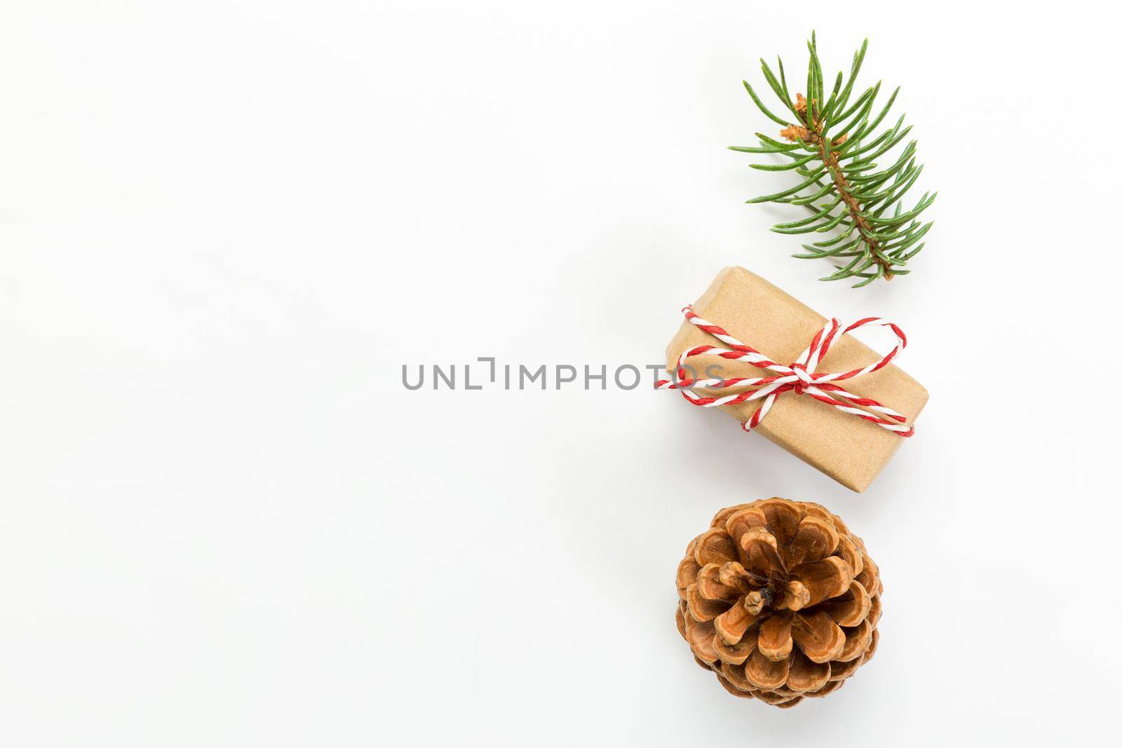Christmas composition with pine cones fir tree branches and christmas gift box. Top view, flat lay on white background.