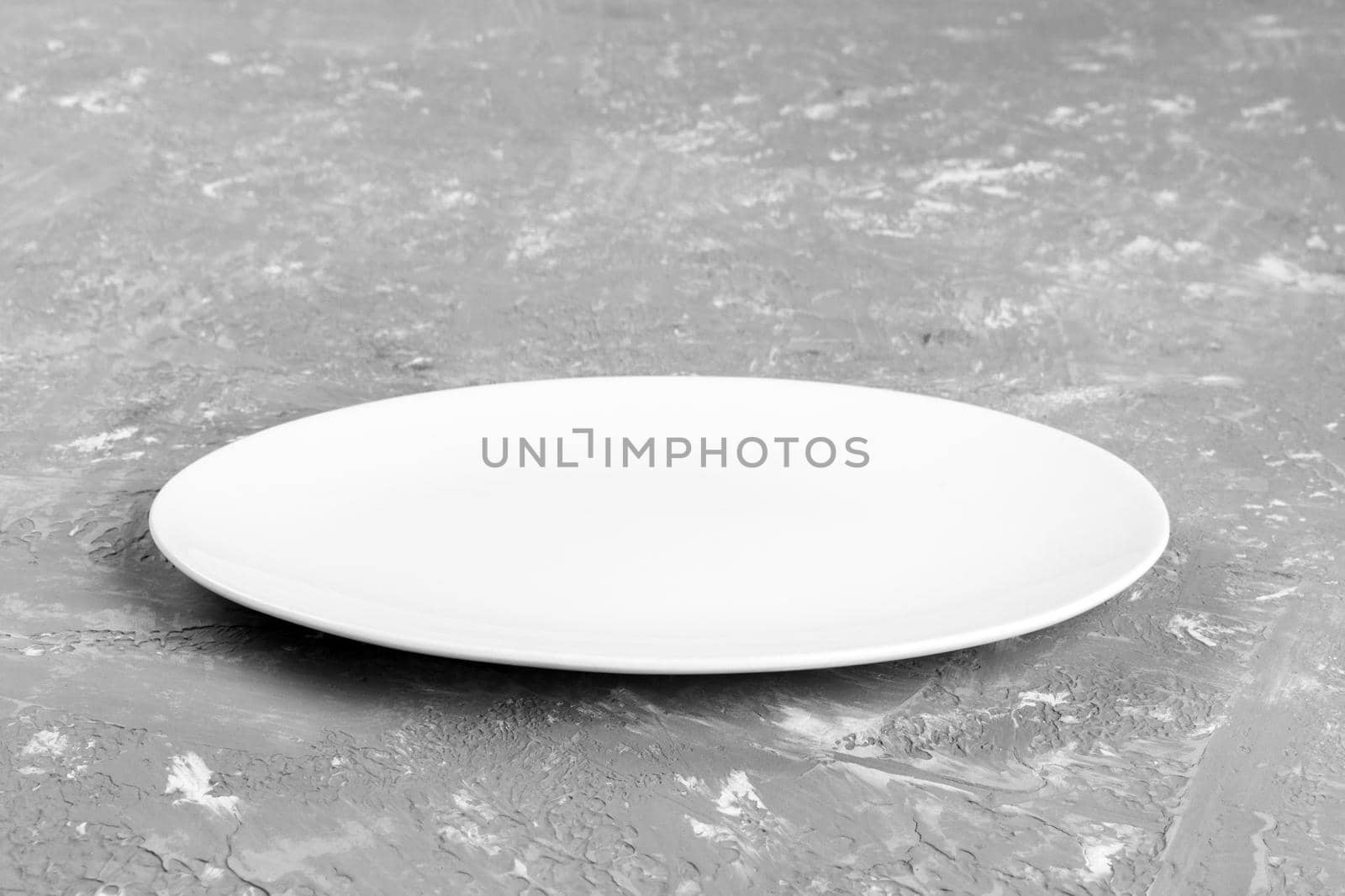 Empty plate on cement background. perspective view.