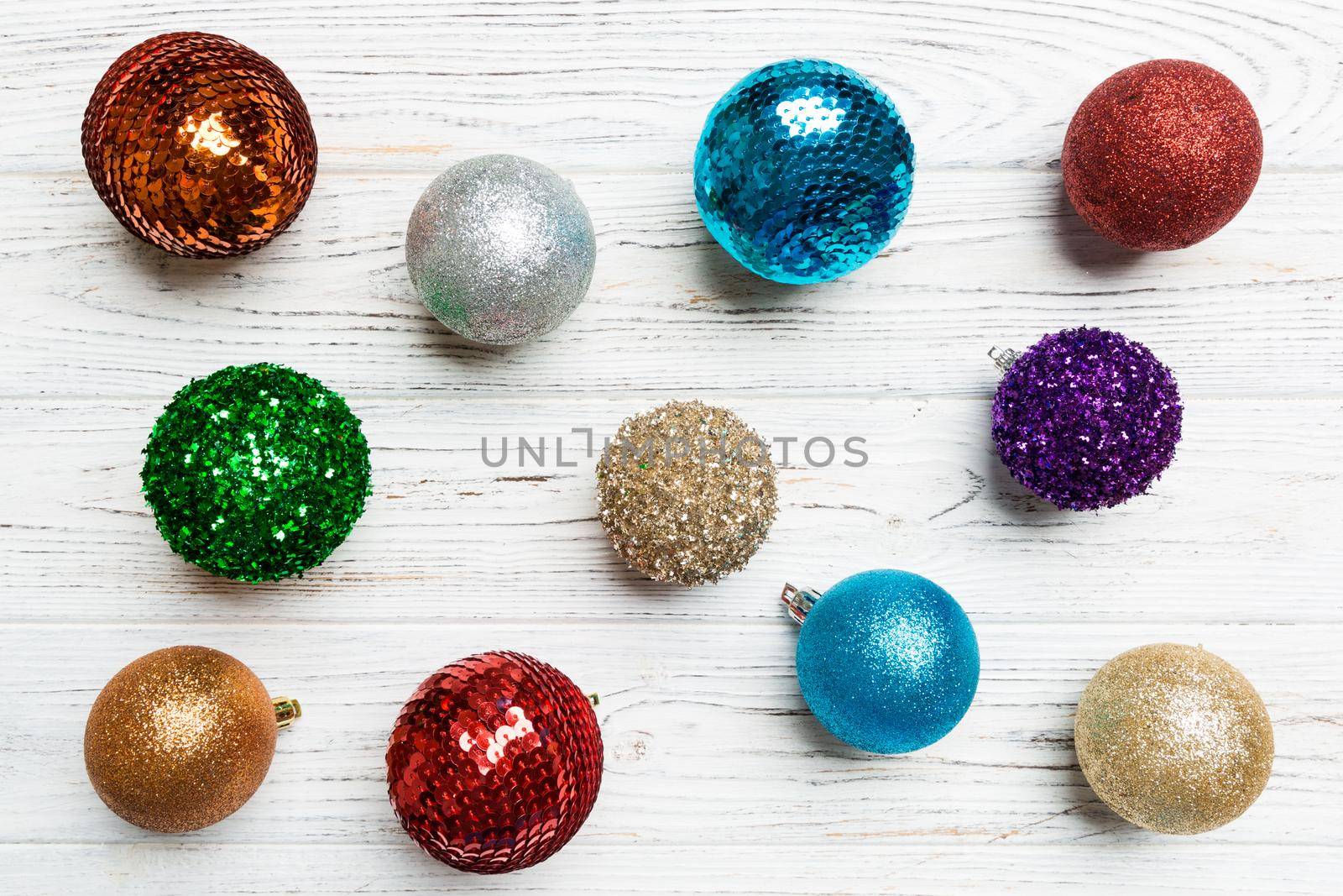 Top view of creative holiday baubles on wooden background. Christmas ornament concept.