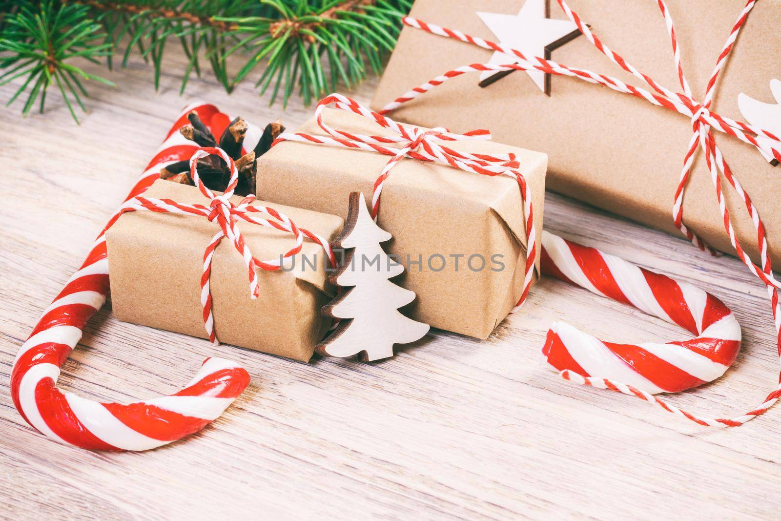 Christmas gifts with Fir tree and decorative cone. Sweets and gifts for holidays. colored candies. Snowflakes. Xmas and Happy New Year composition. Flat lay, top view. Toned.