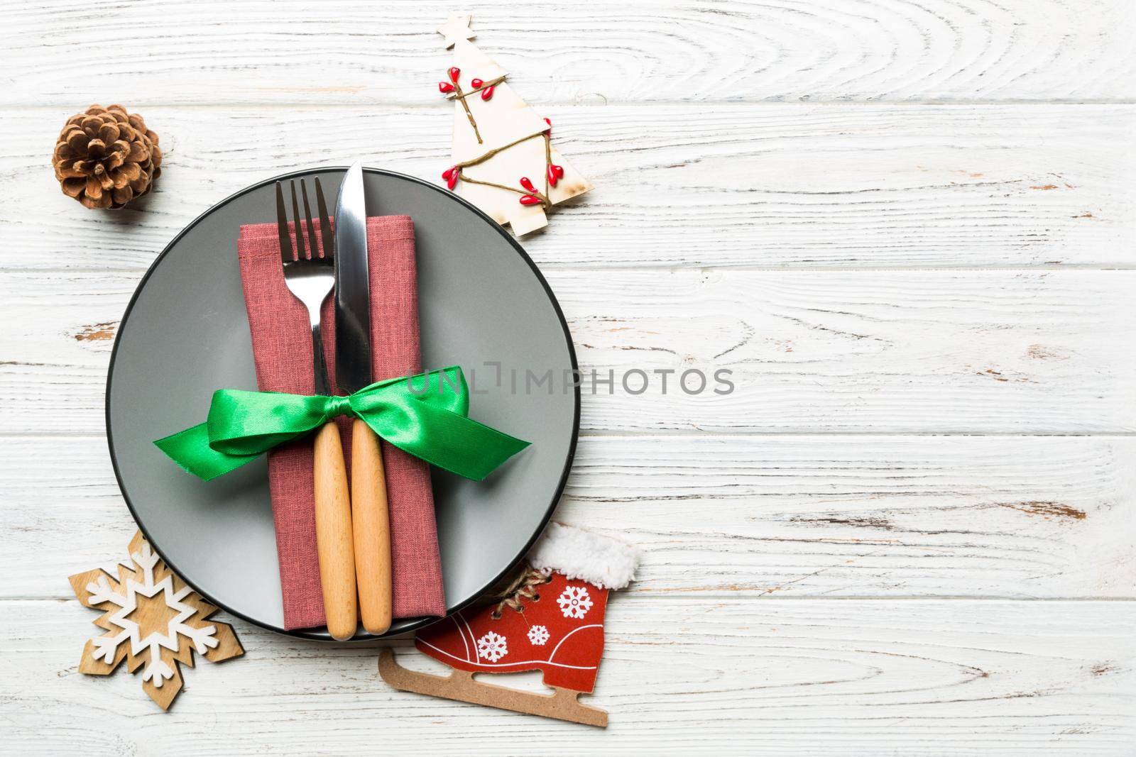 Holiday composition of Christmas dinner on wooden background. Top view of plate, utensil and festive decorations. New Year Advent concept with copy space.