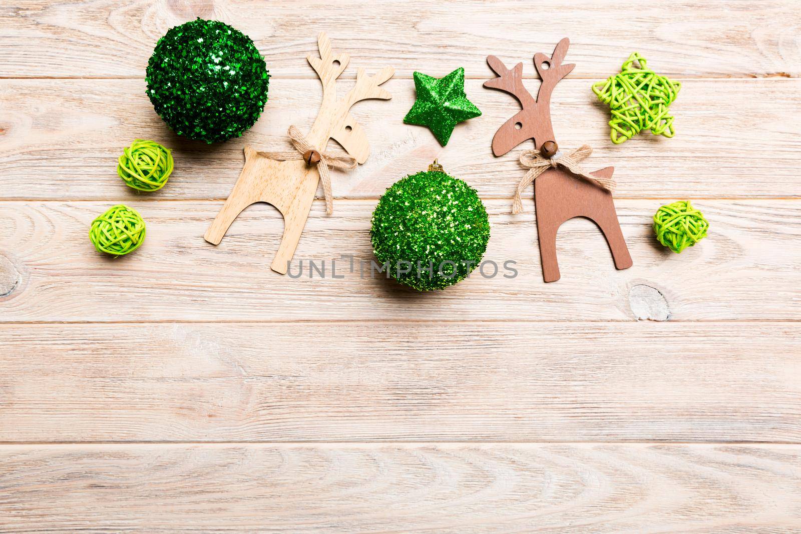 New Year composition made of baubles, reindeer and other decorations on wooden background. Christmas time concept with empty space for your design.