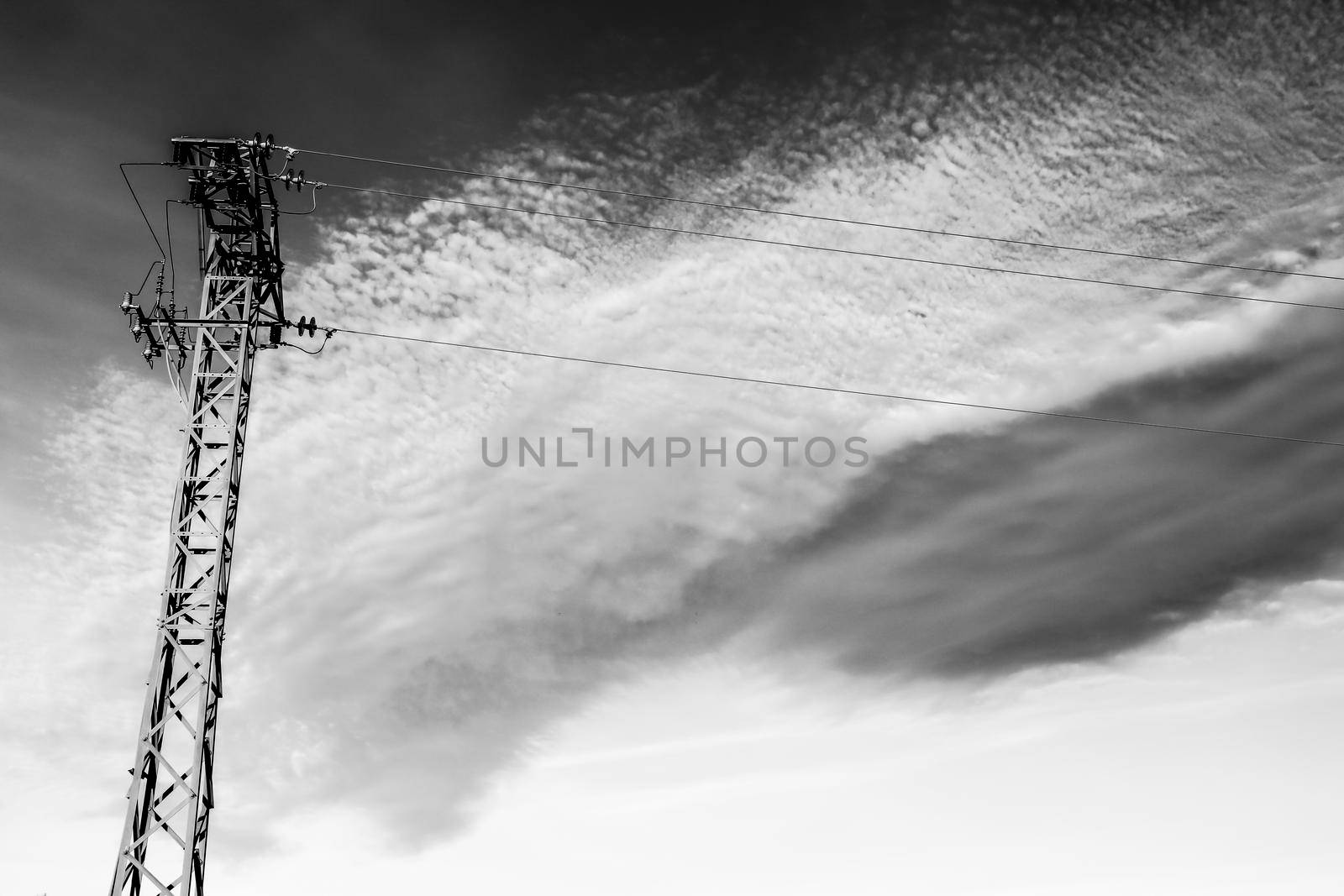 Power lines tower under cloudy sky in the countryside by soniabonet