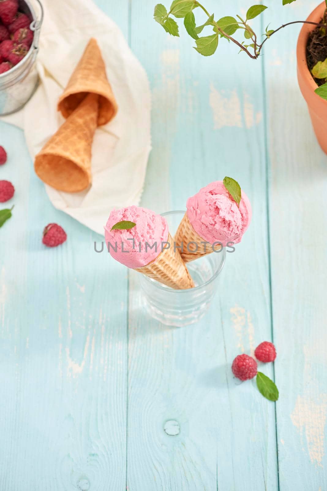 Homemade raspberry ice cream in waffle cones on rustic wooden background, selective focus. Summer time by makidotvn